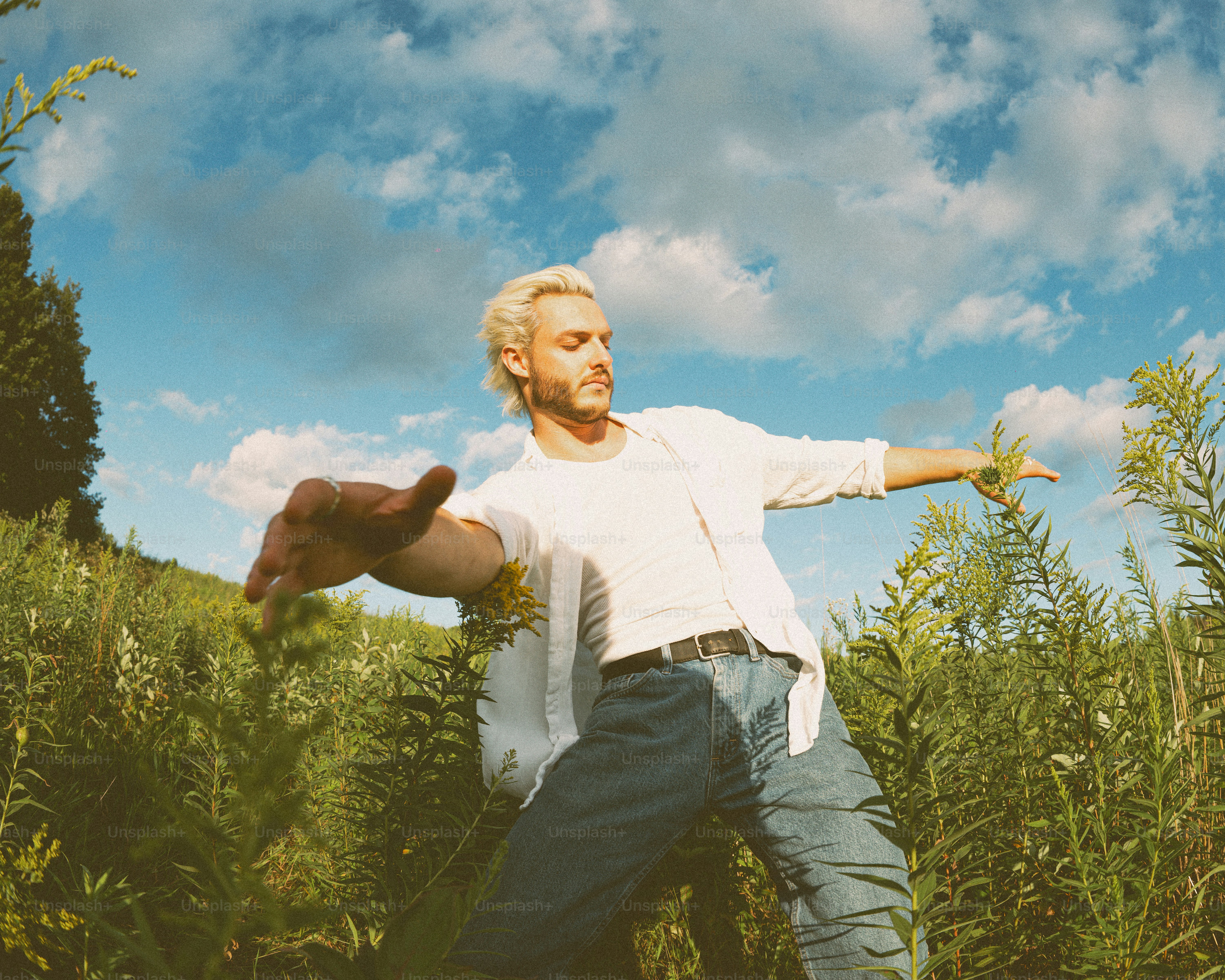 A man standing in a field with his arms outstretched