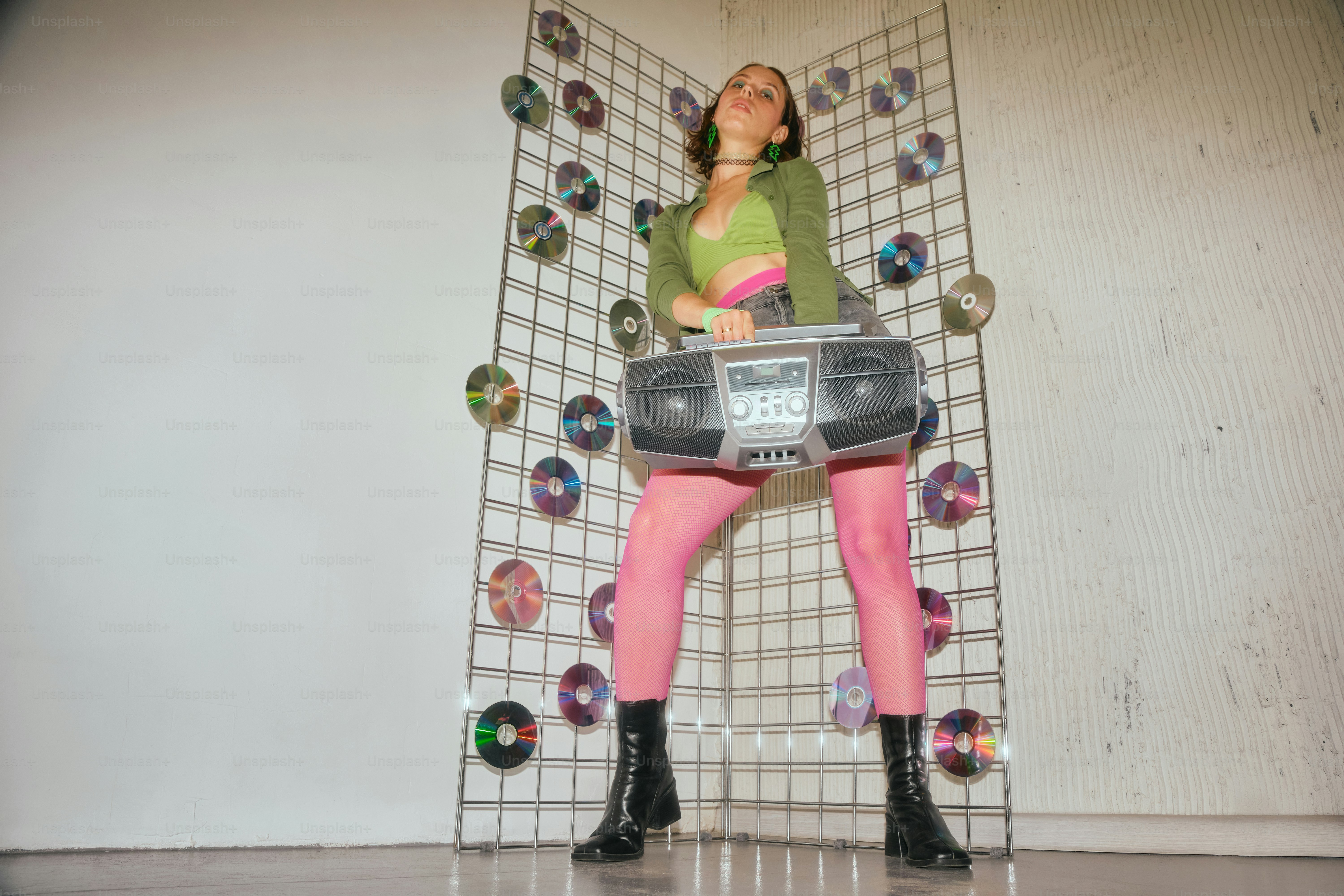 Eine Frau mit einem Koffer, die vor einer Wand steht