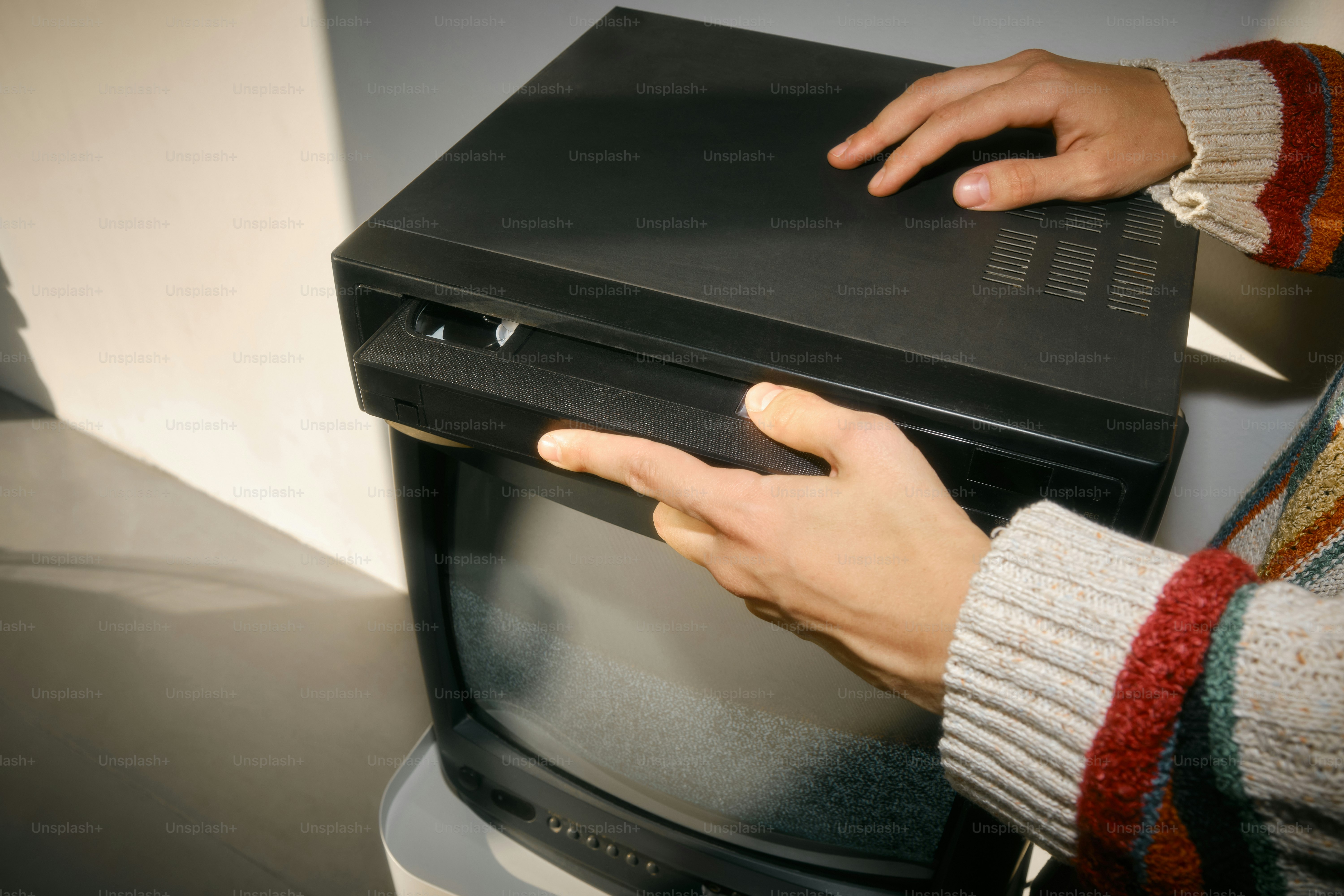 Seseorang menggunakan komputer di atas TV