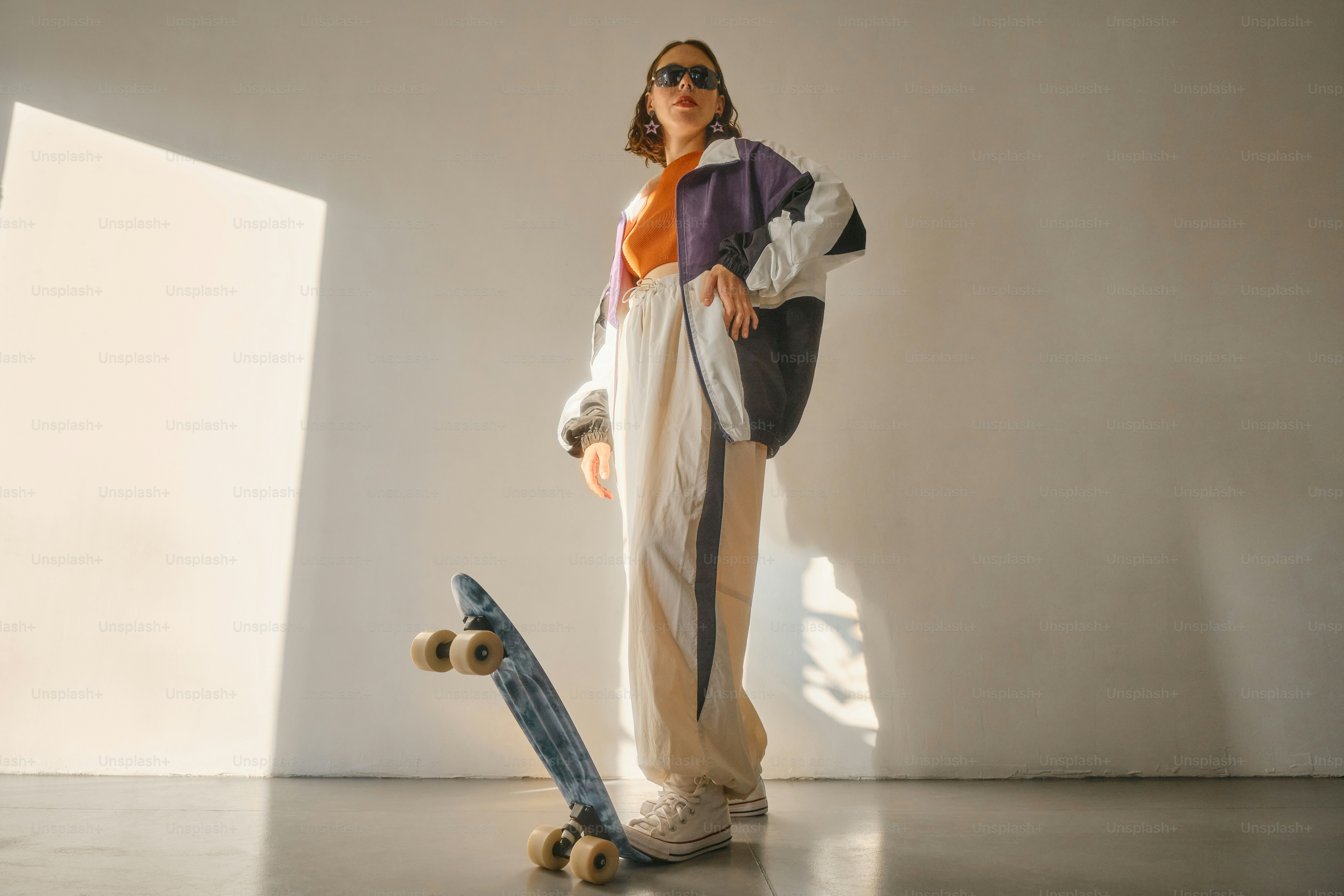 Eine Frau, die neben einem Skateboard in einem Raum steht