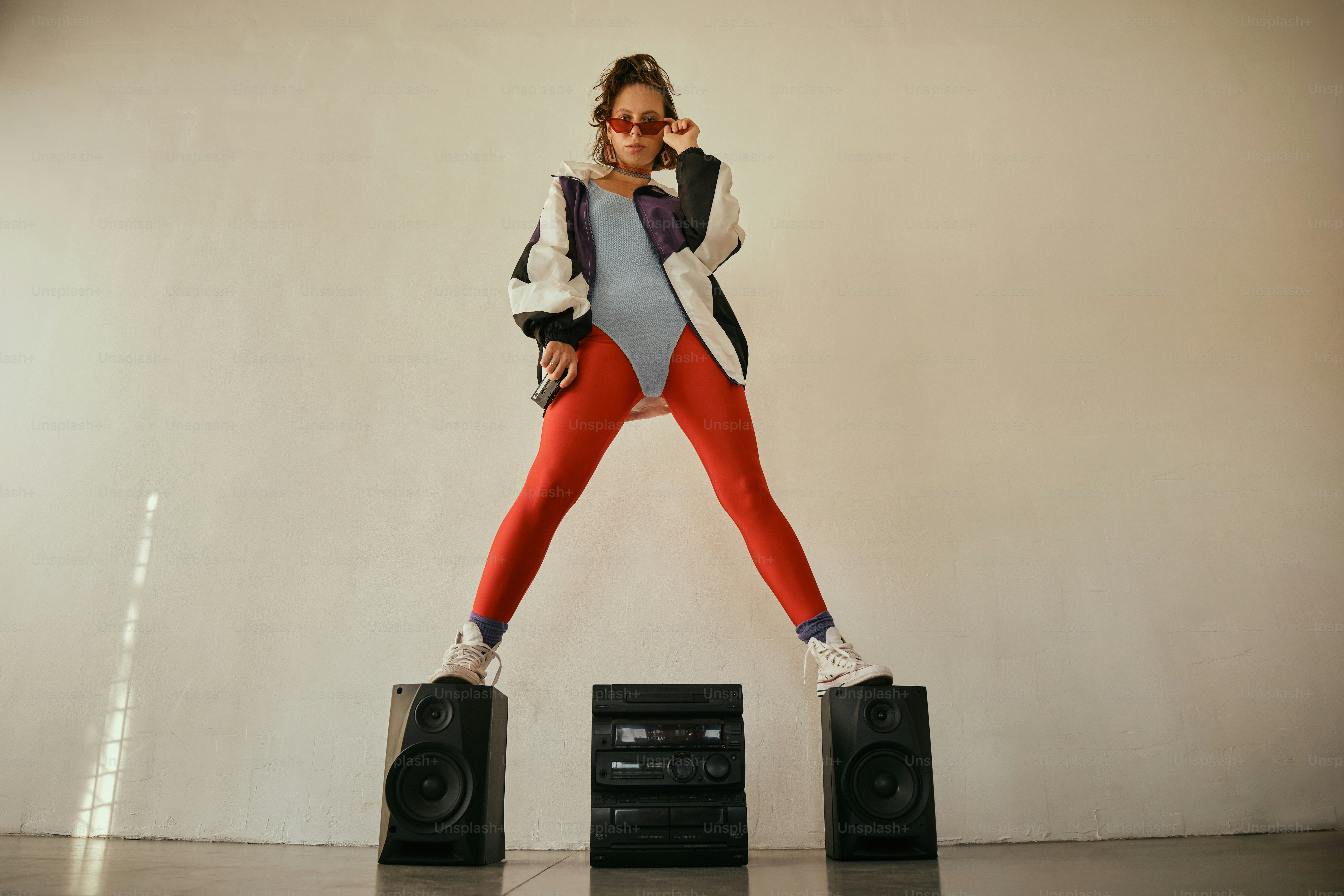 A woman standing on top of two speakers