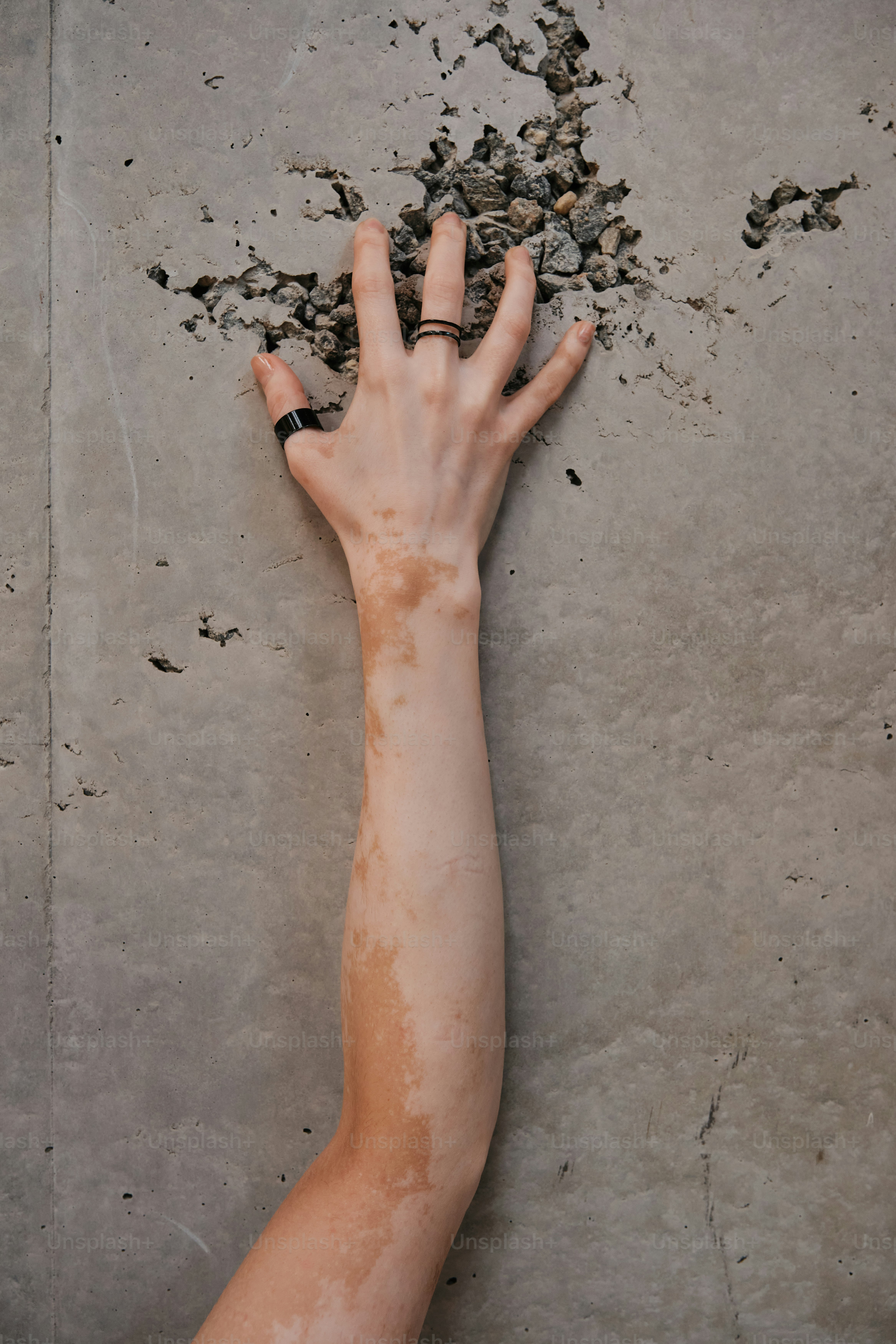 A person's hand reaching for something on a concrete floor