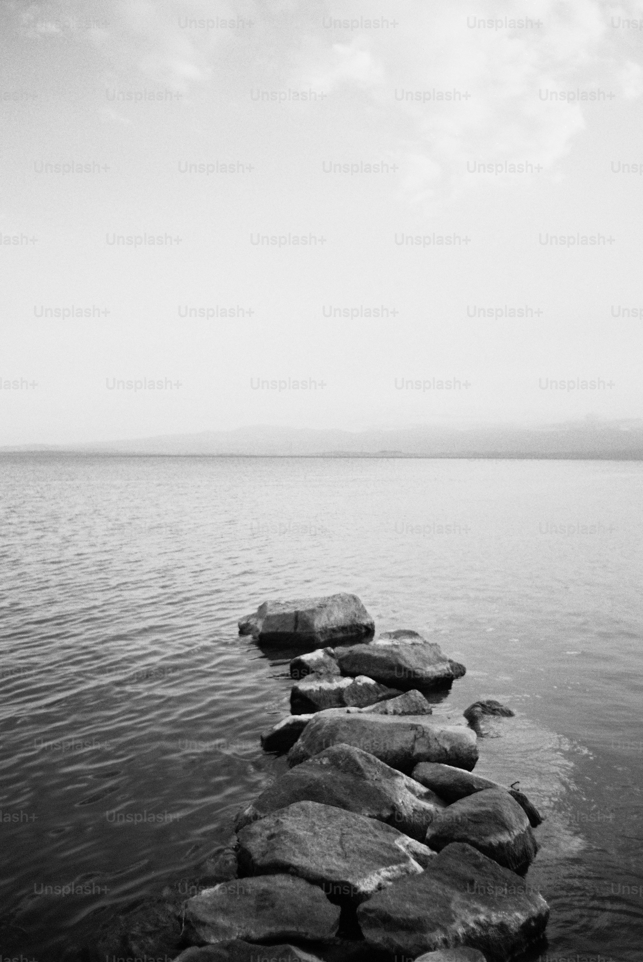 A black and white photo of rocks in the water