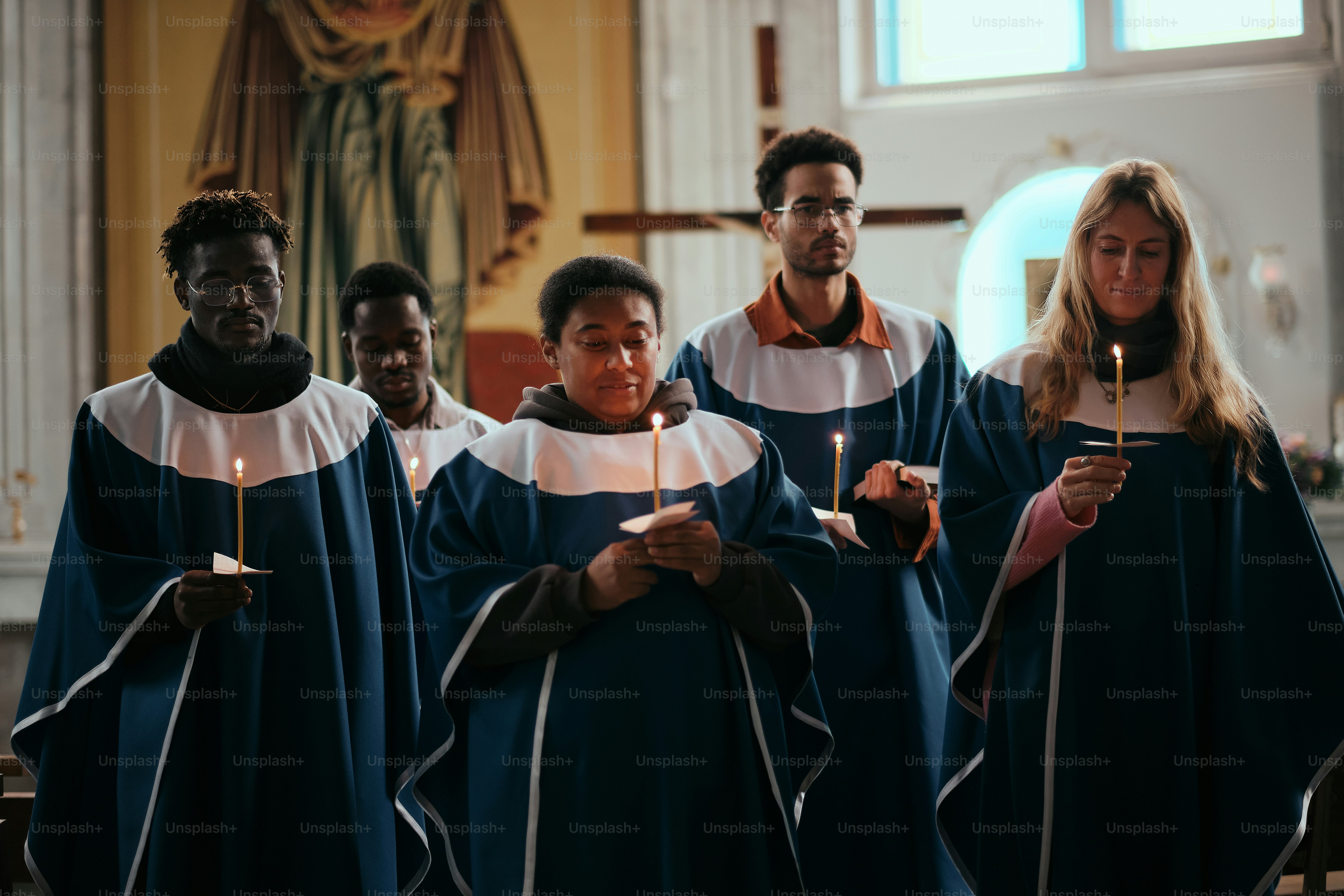 Un grupo de personas de pie una alrededor de la otra sosteniendo velas