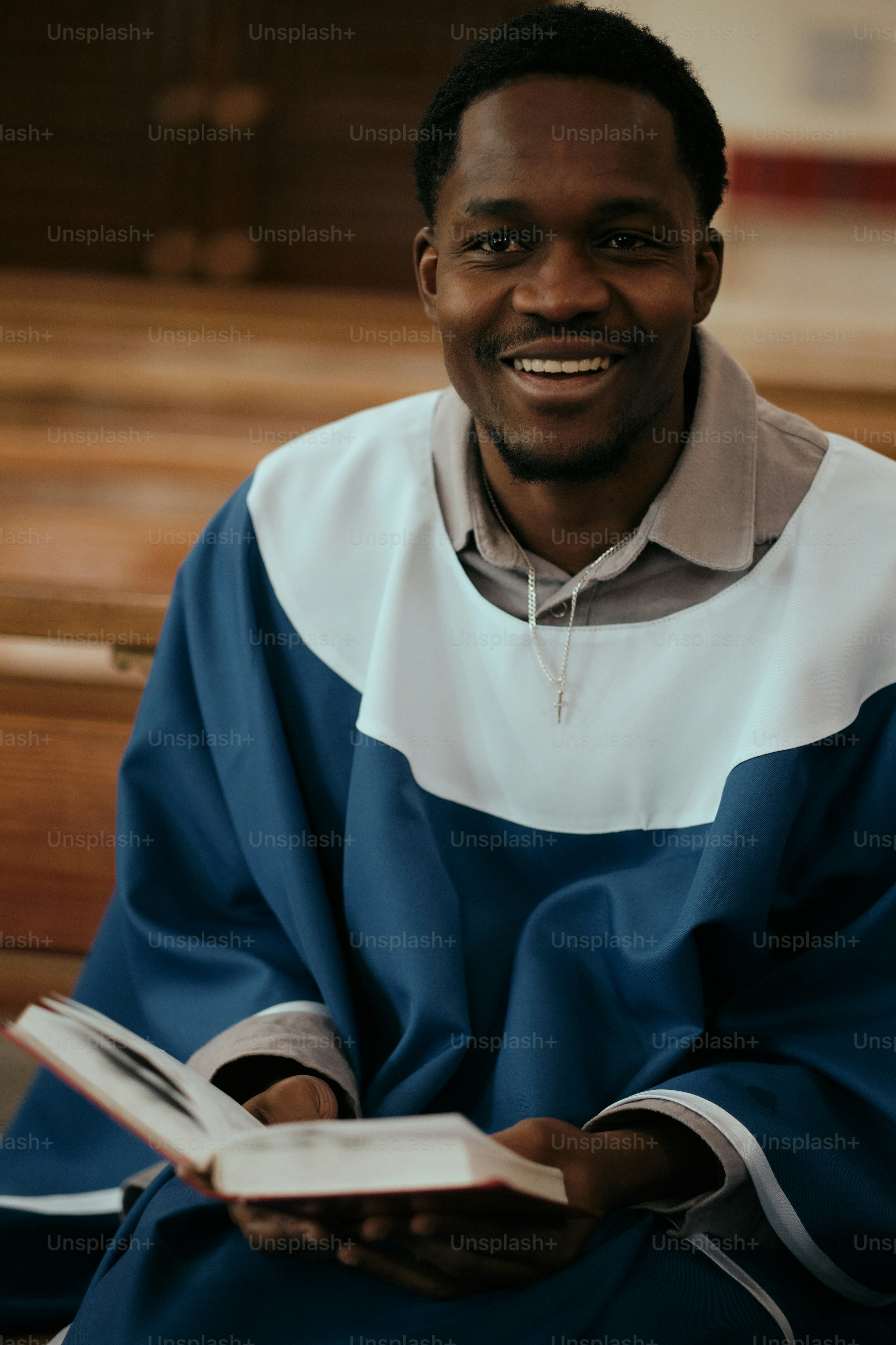 A man sitting on a bench holding a book