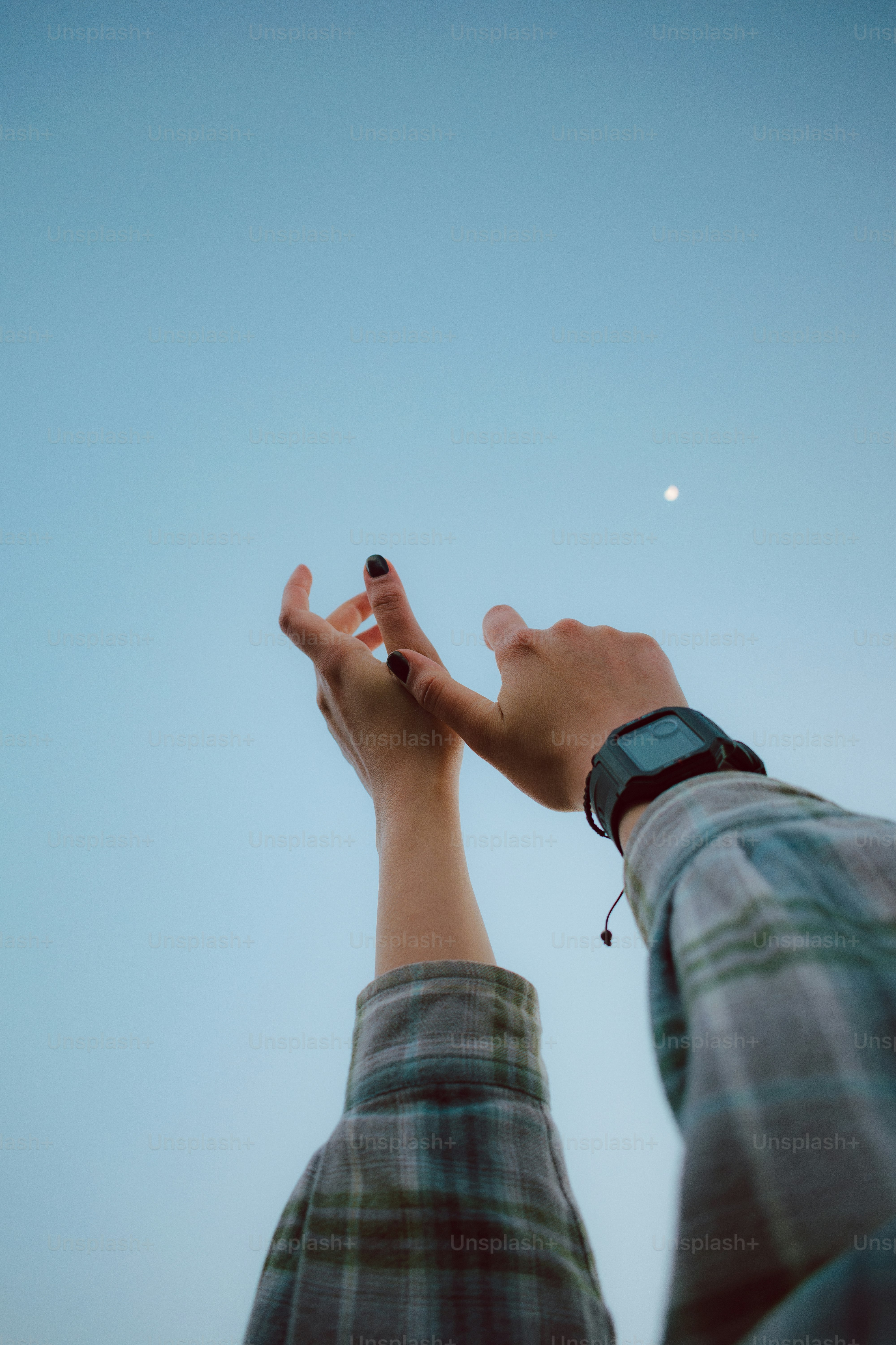 A person reaching up into the sky with their hands