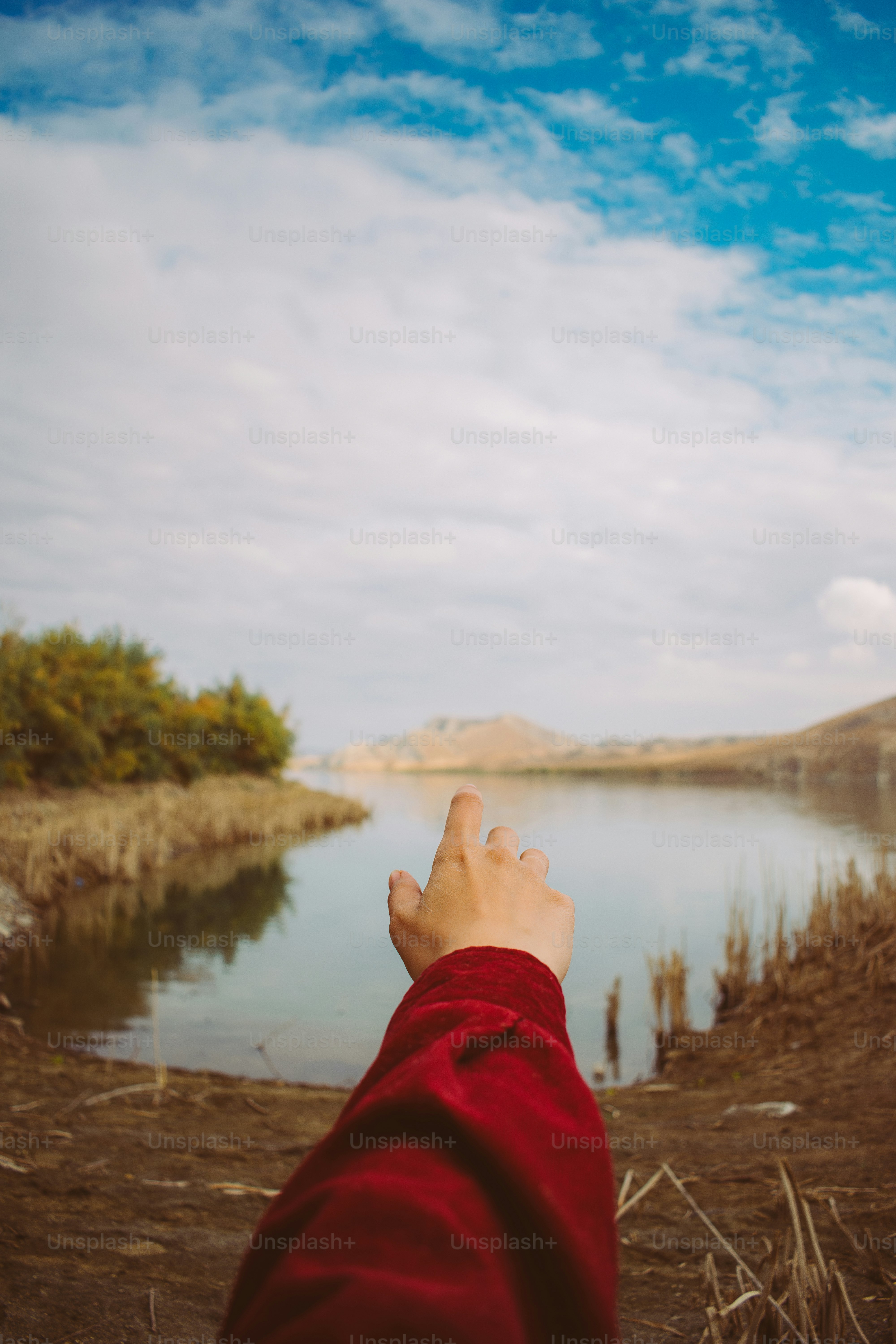 Una persona in piedi di fronte a uno specchio d'acqua