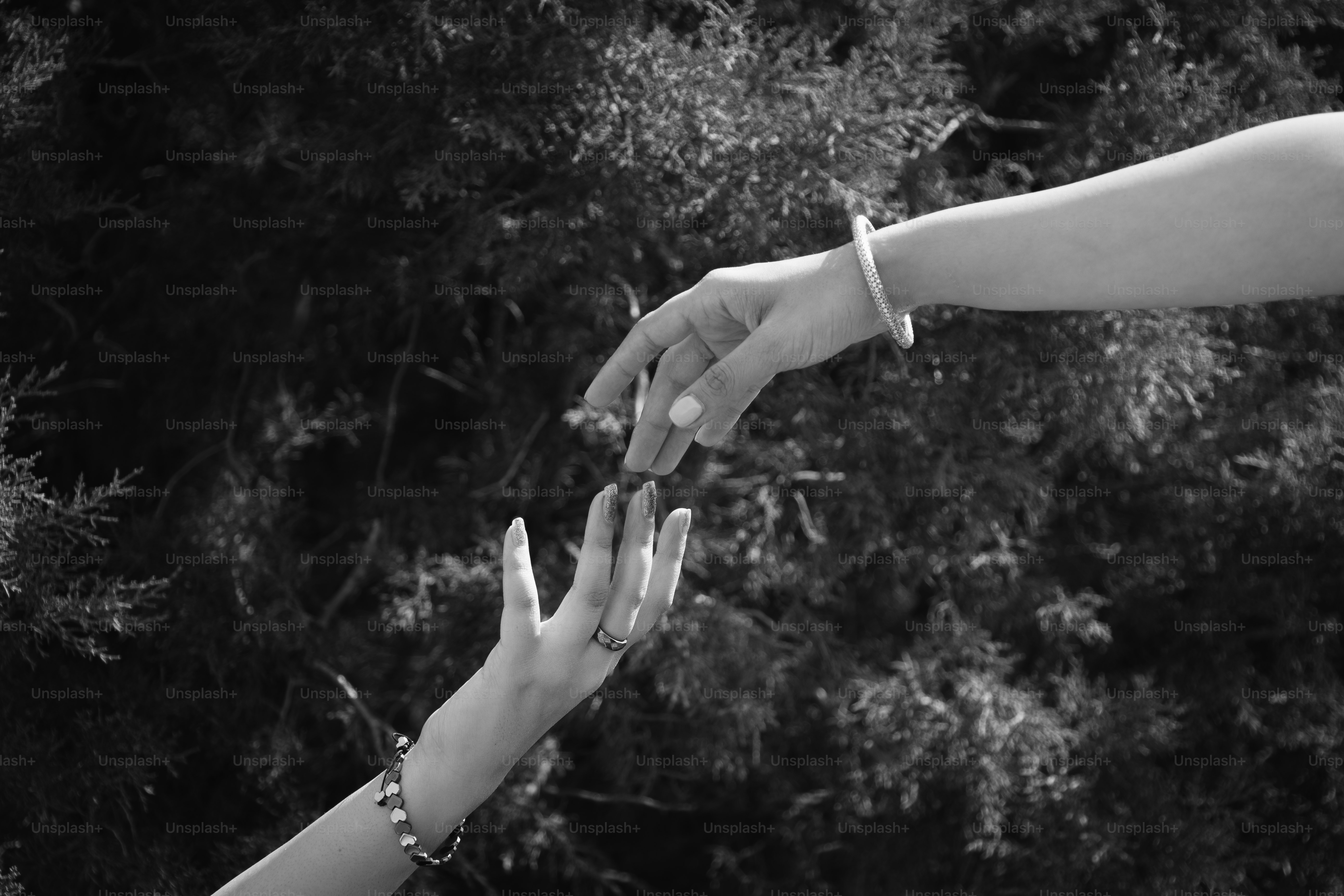 Two people reaching out their hands to touch each other