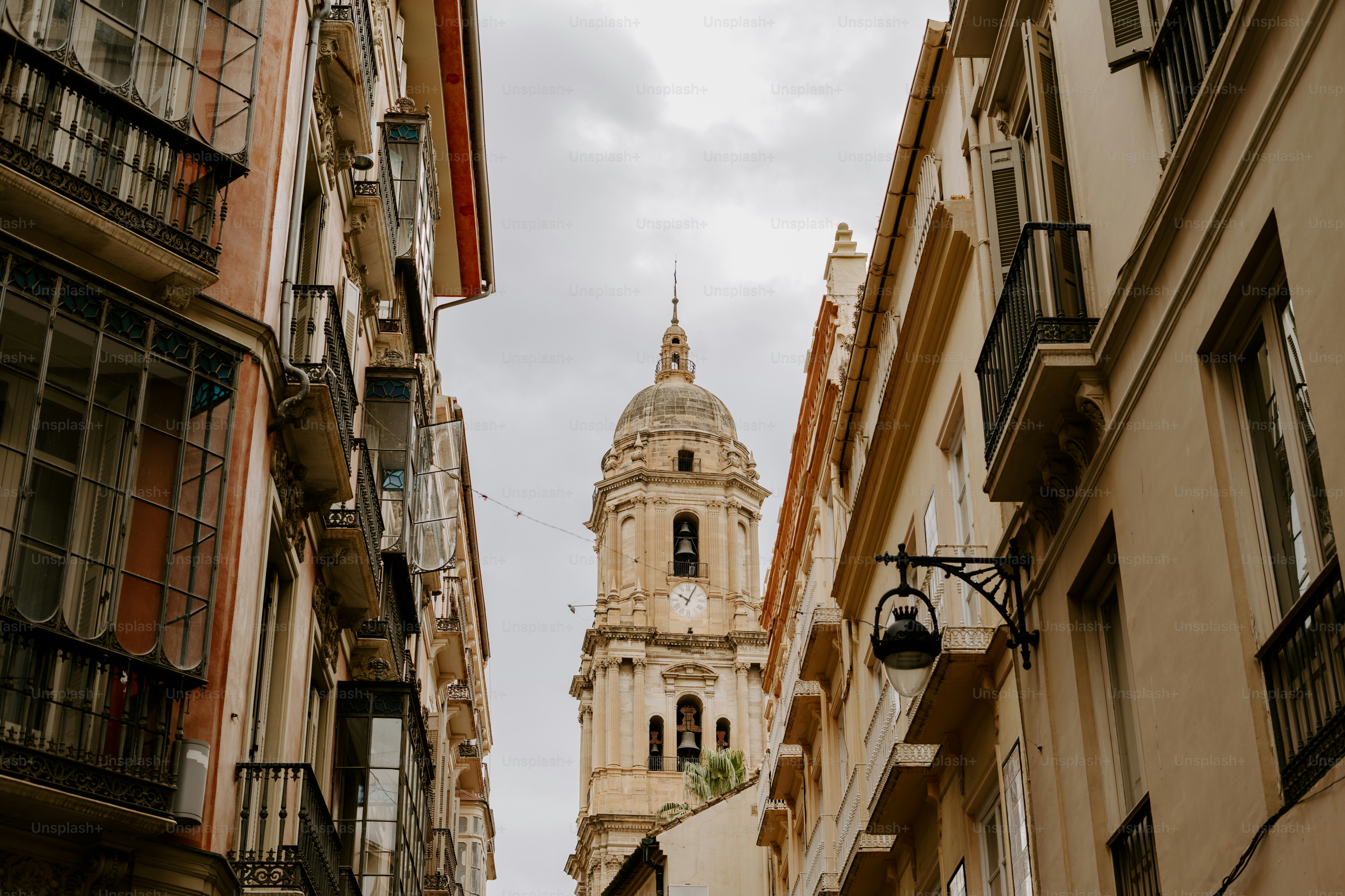 Eine schmale Stadtstraße mit einem Kirchturm im Hintergrund