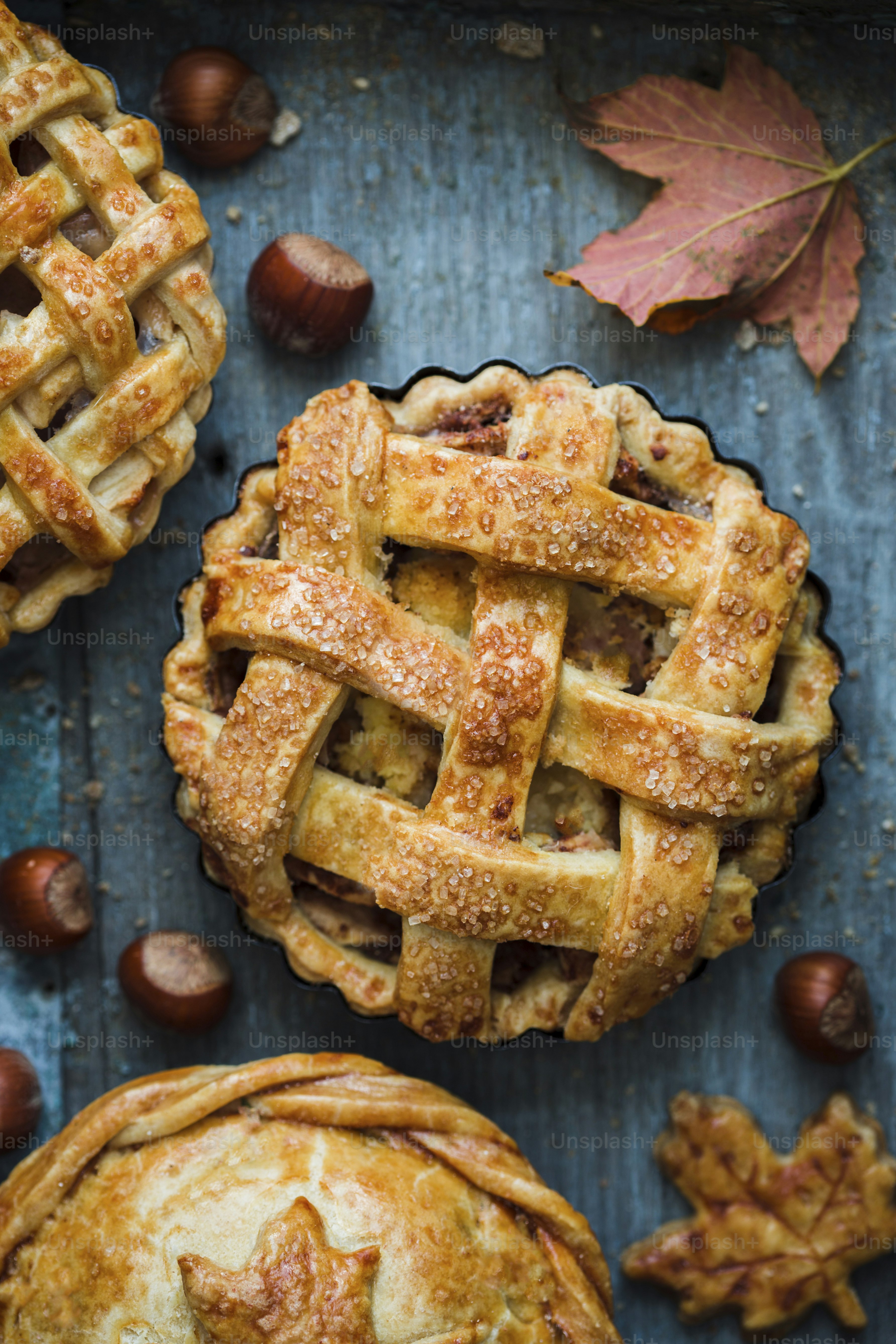 A table topped with three pies covered in toppings