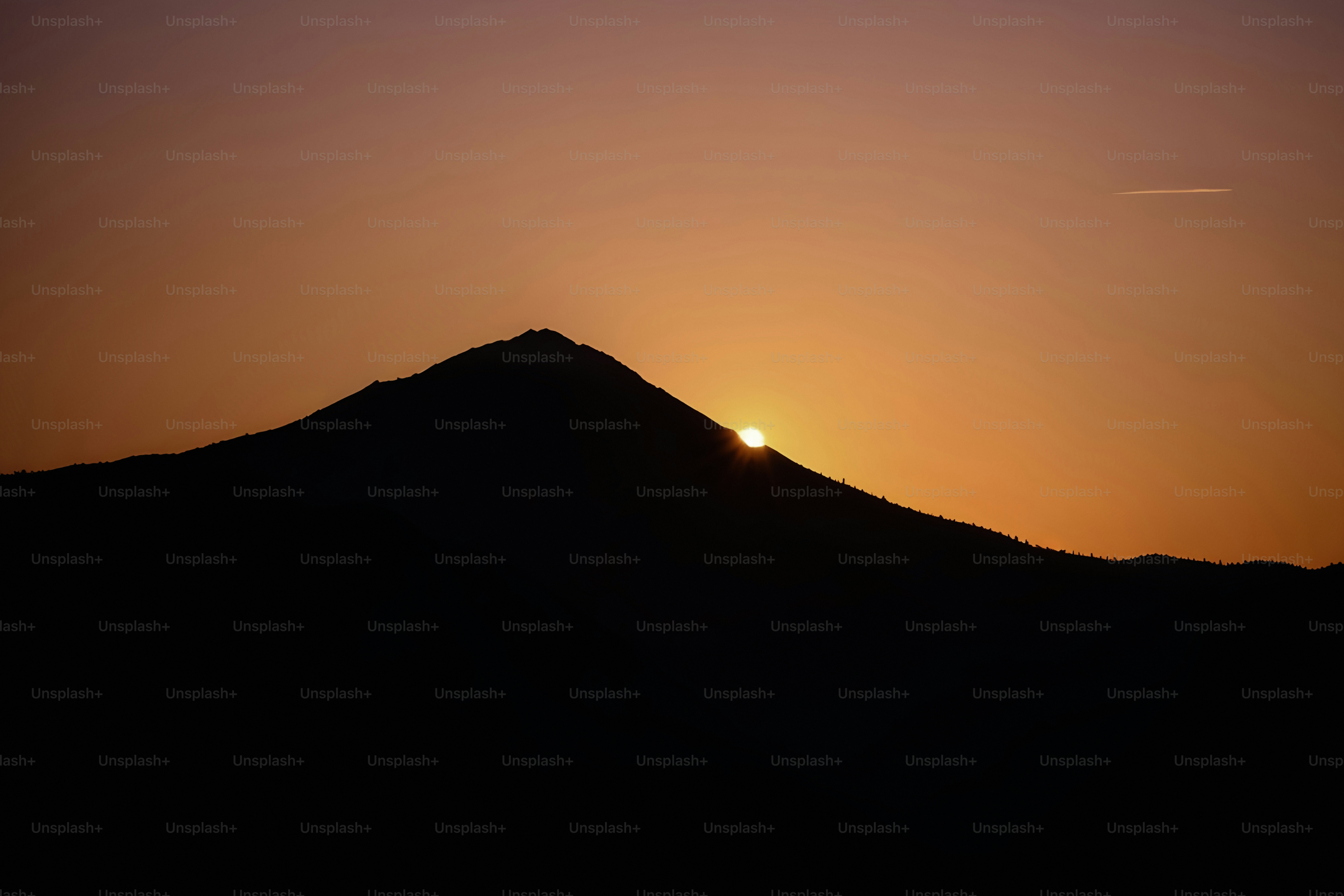 The sun is setting over a mountain range