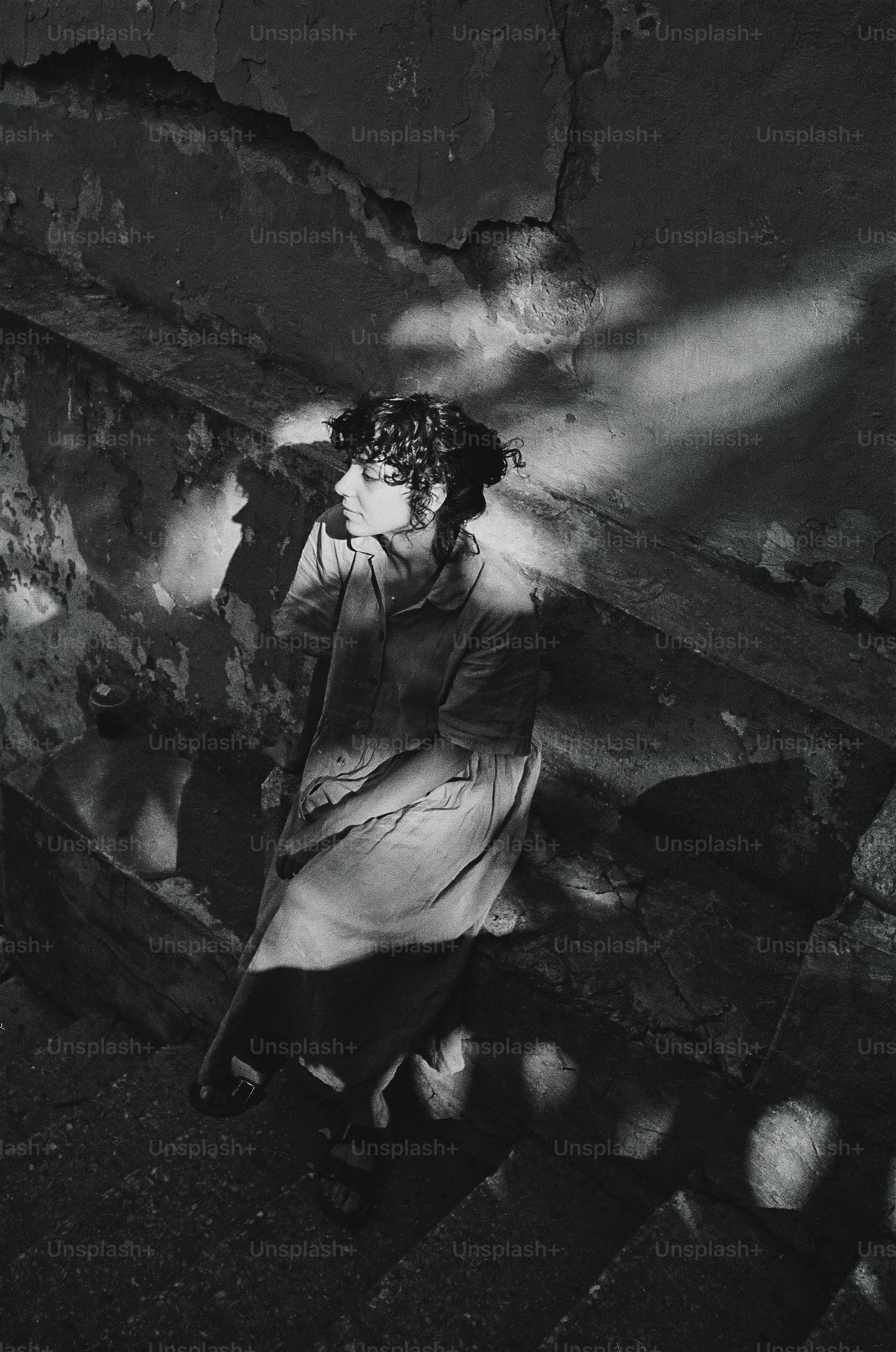 A black and white photo of a woman walking up a flight of stairs