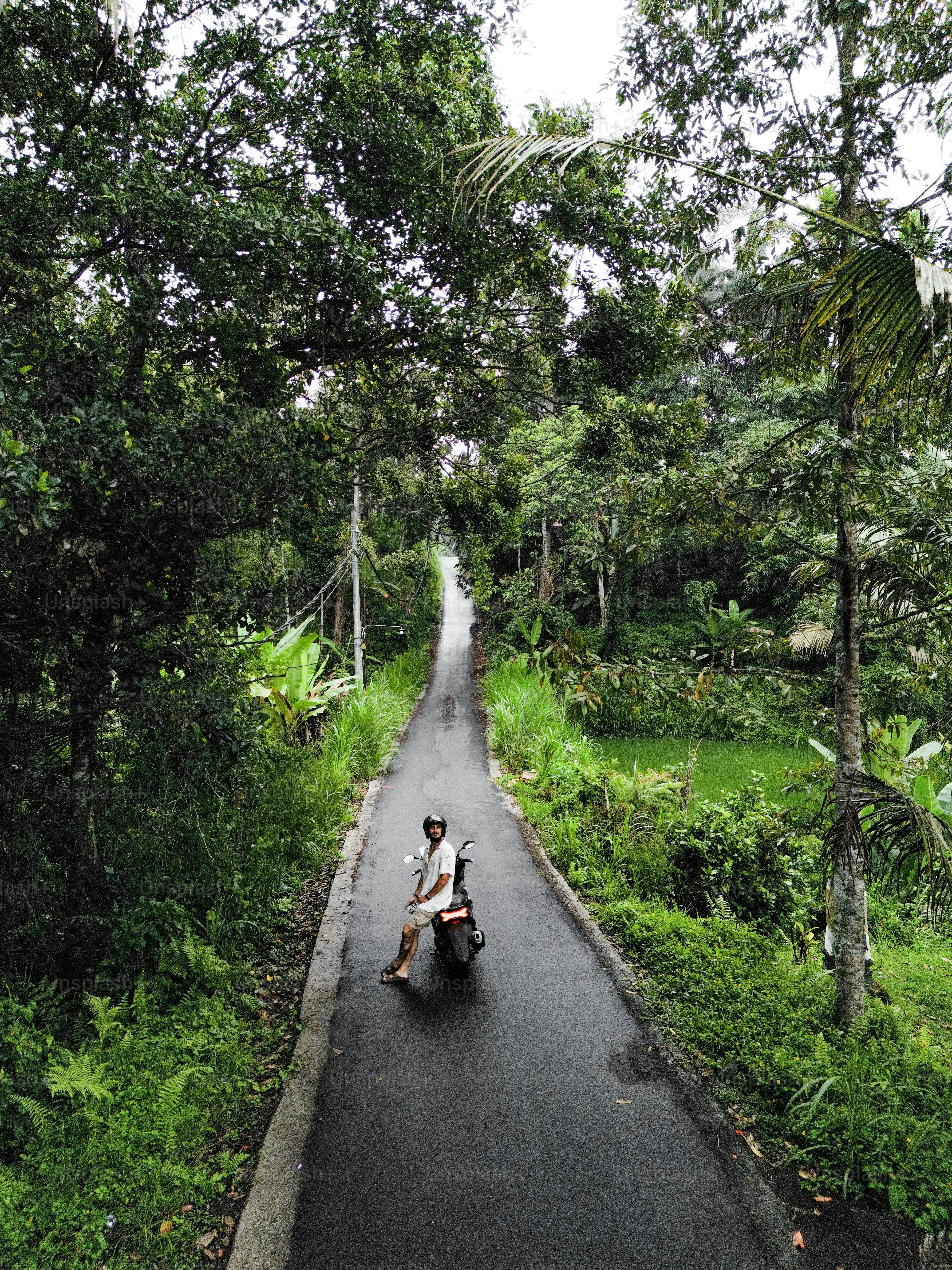 Seseorang mengendarai sepeda motor di jalan sempit
