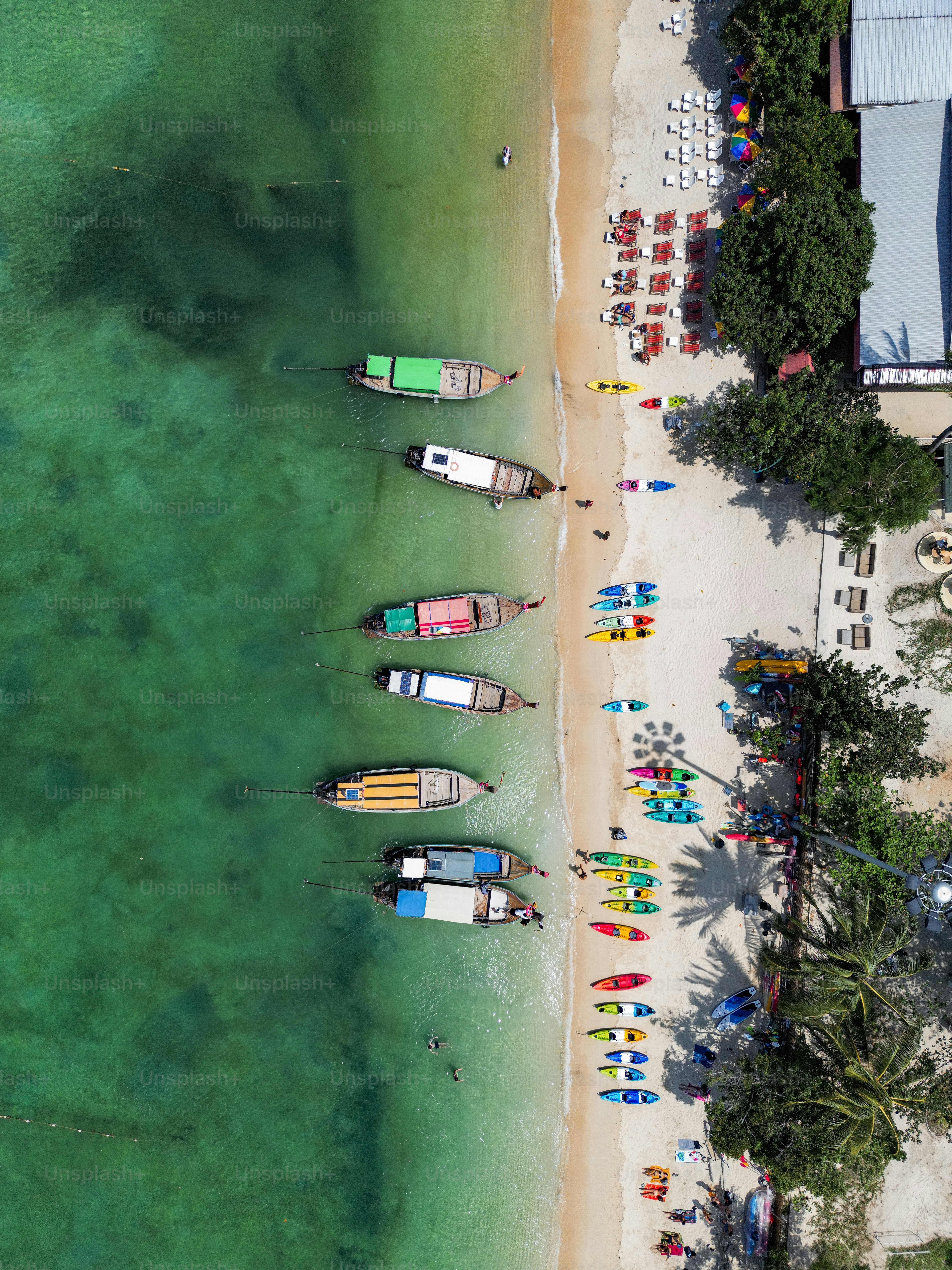 海の隣のビーチの上に座っているボートのグループ