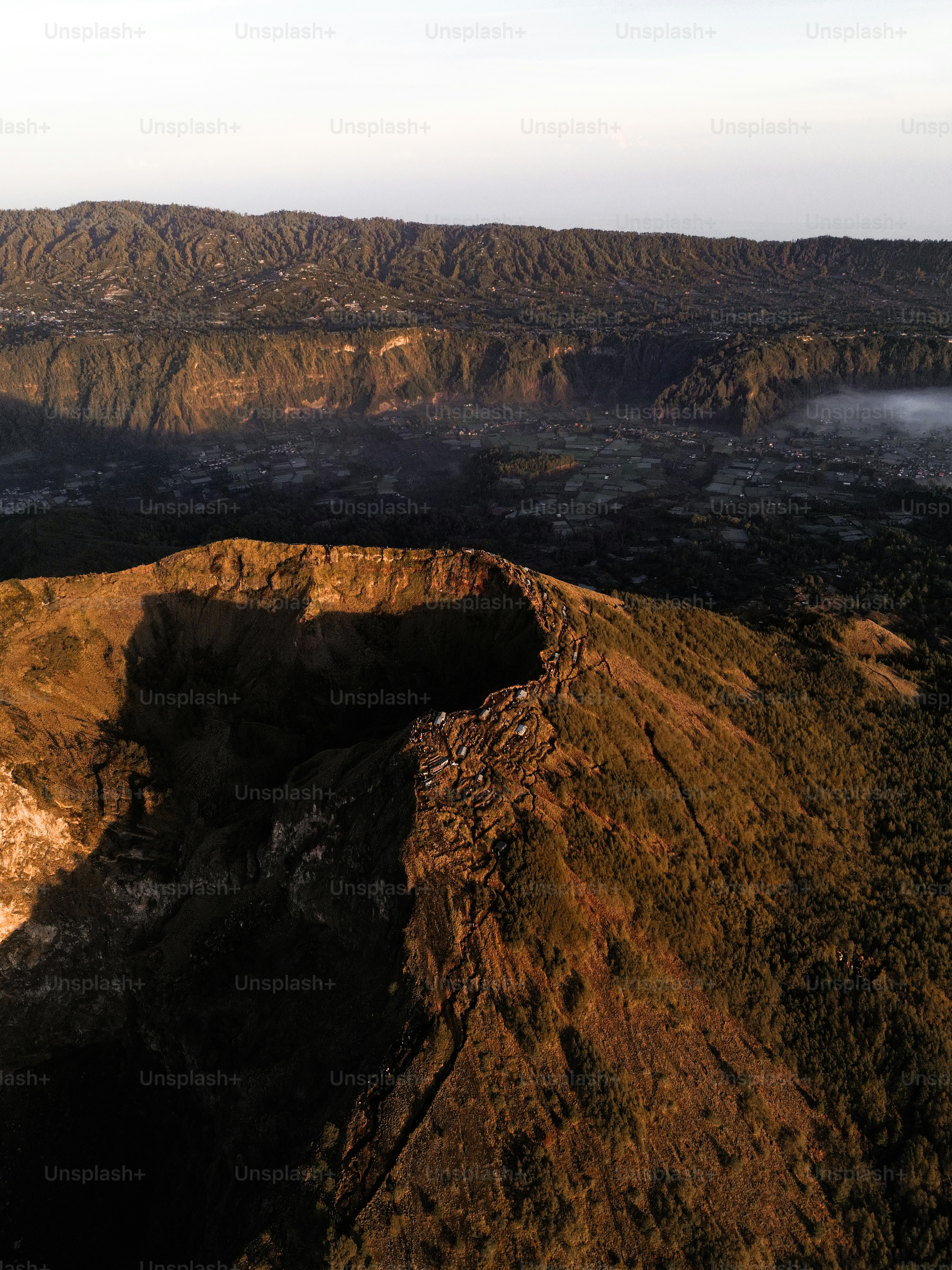 A man standing on top of a mountain with a sky background