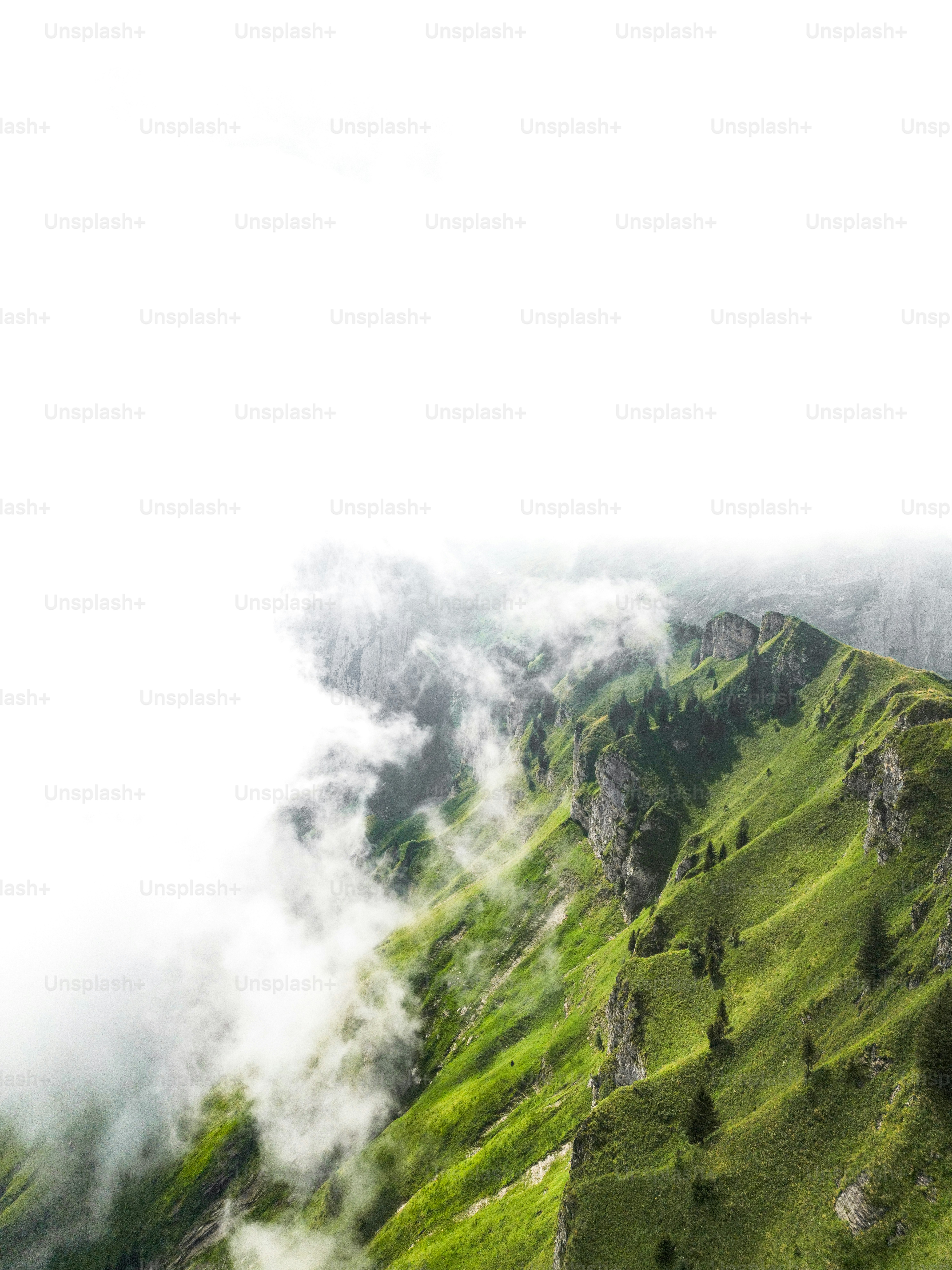 A mountain covered in green grass and clouds photo – Travel Image on ...