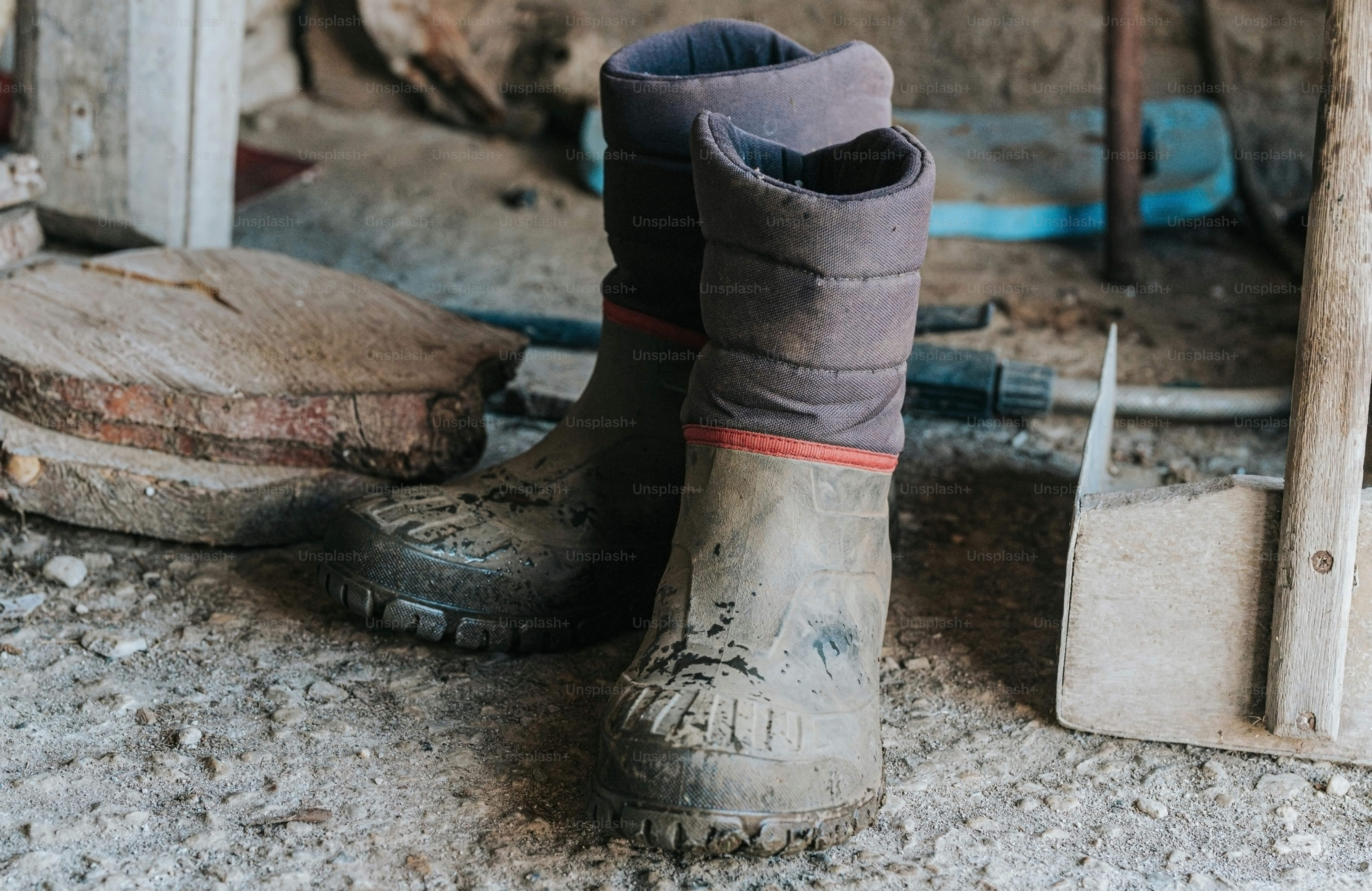 A pair of dirty boots sitting on top of a dirty floor