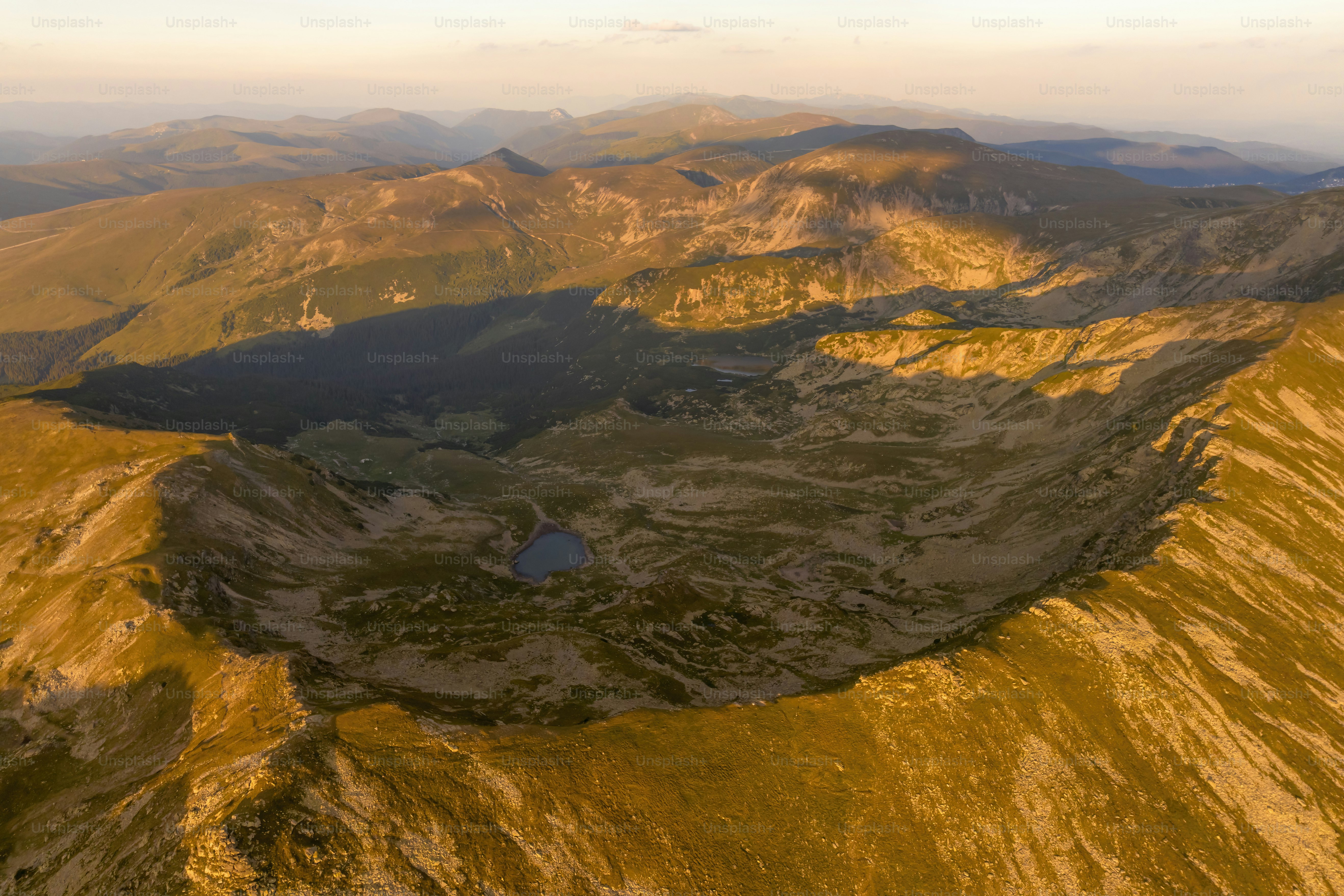 An aerial view of a mountain range with a lake in the middle