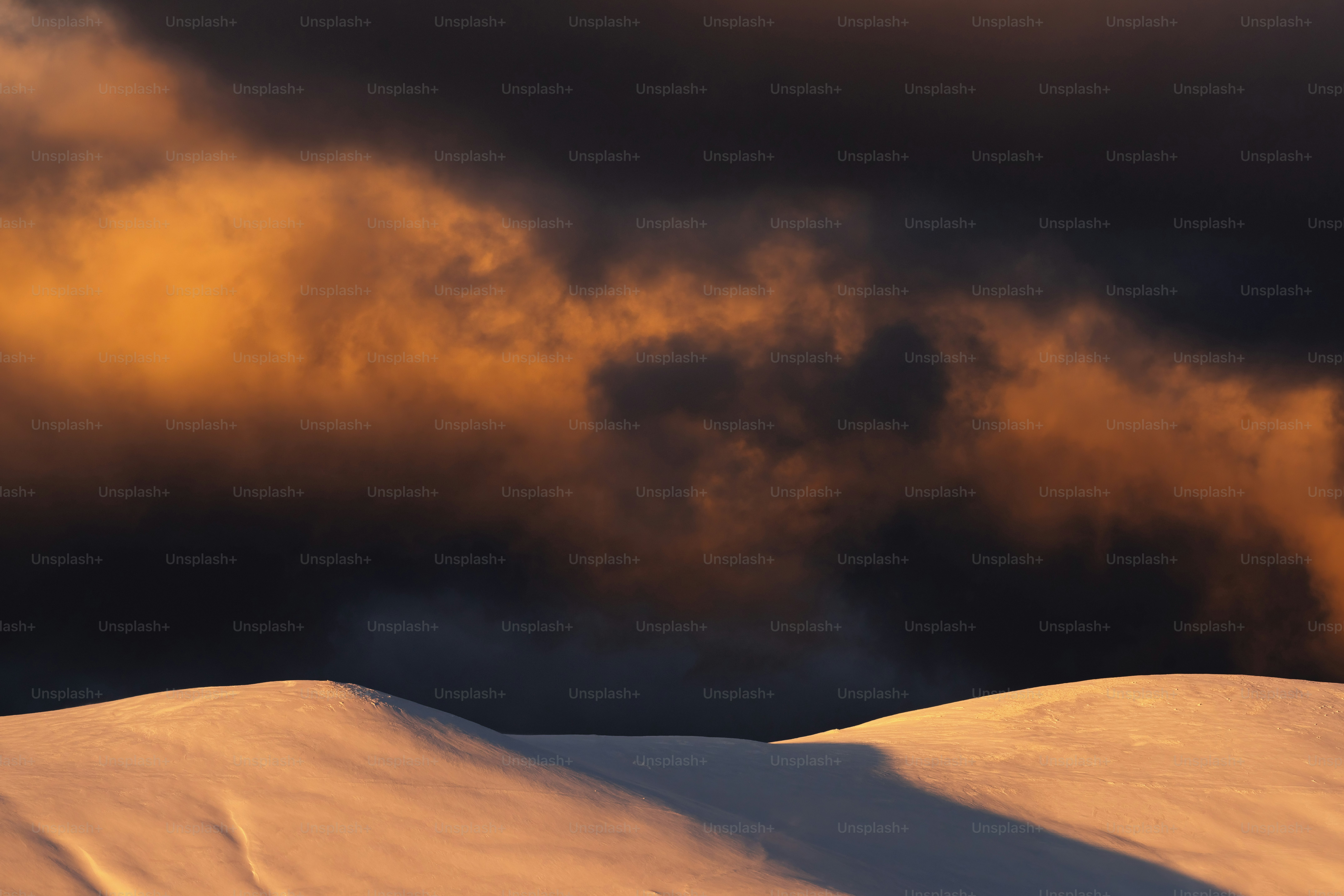 A mountain covered in snow under a cloudy sky