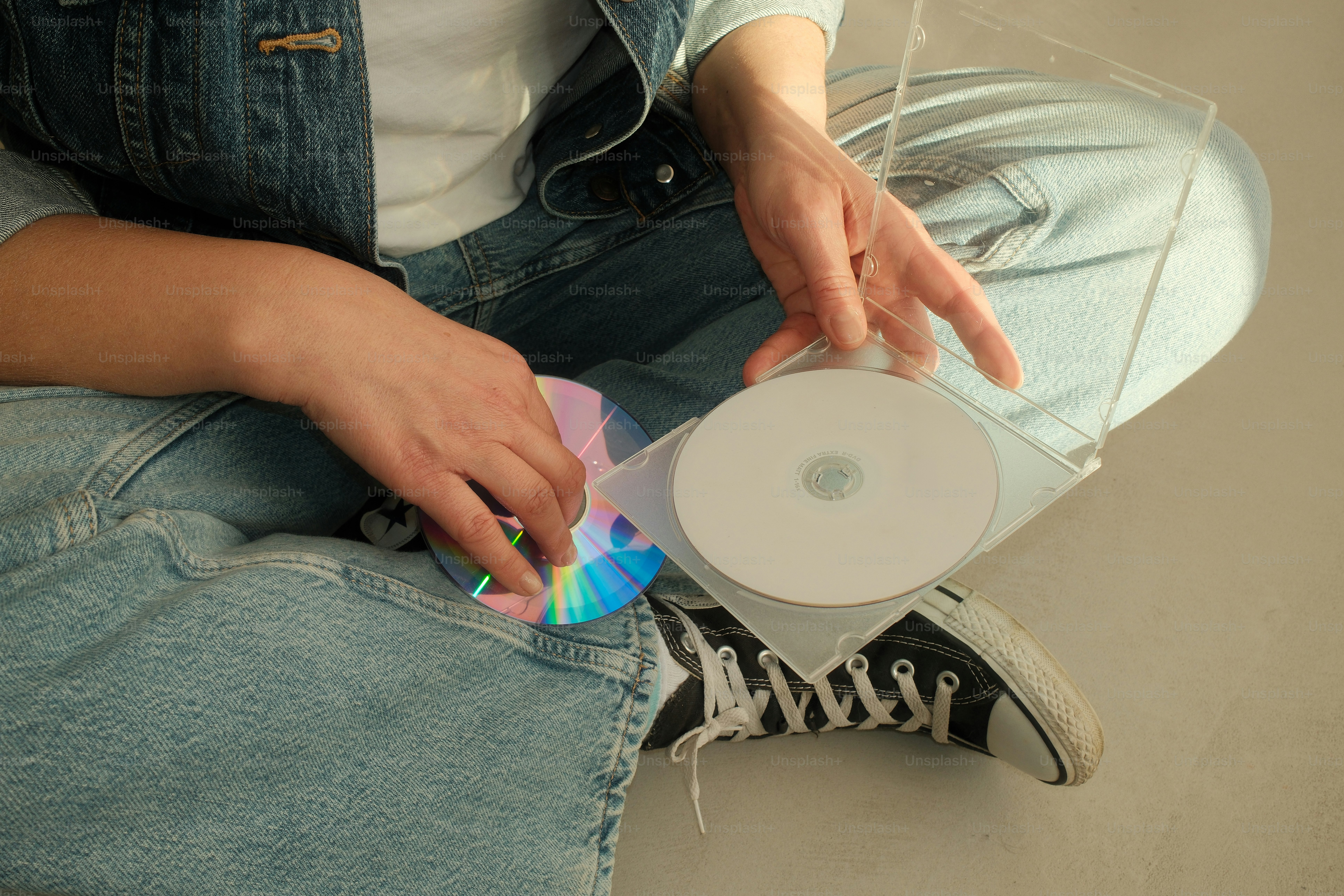 A woman sitting on the floor with a cd in her lap