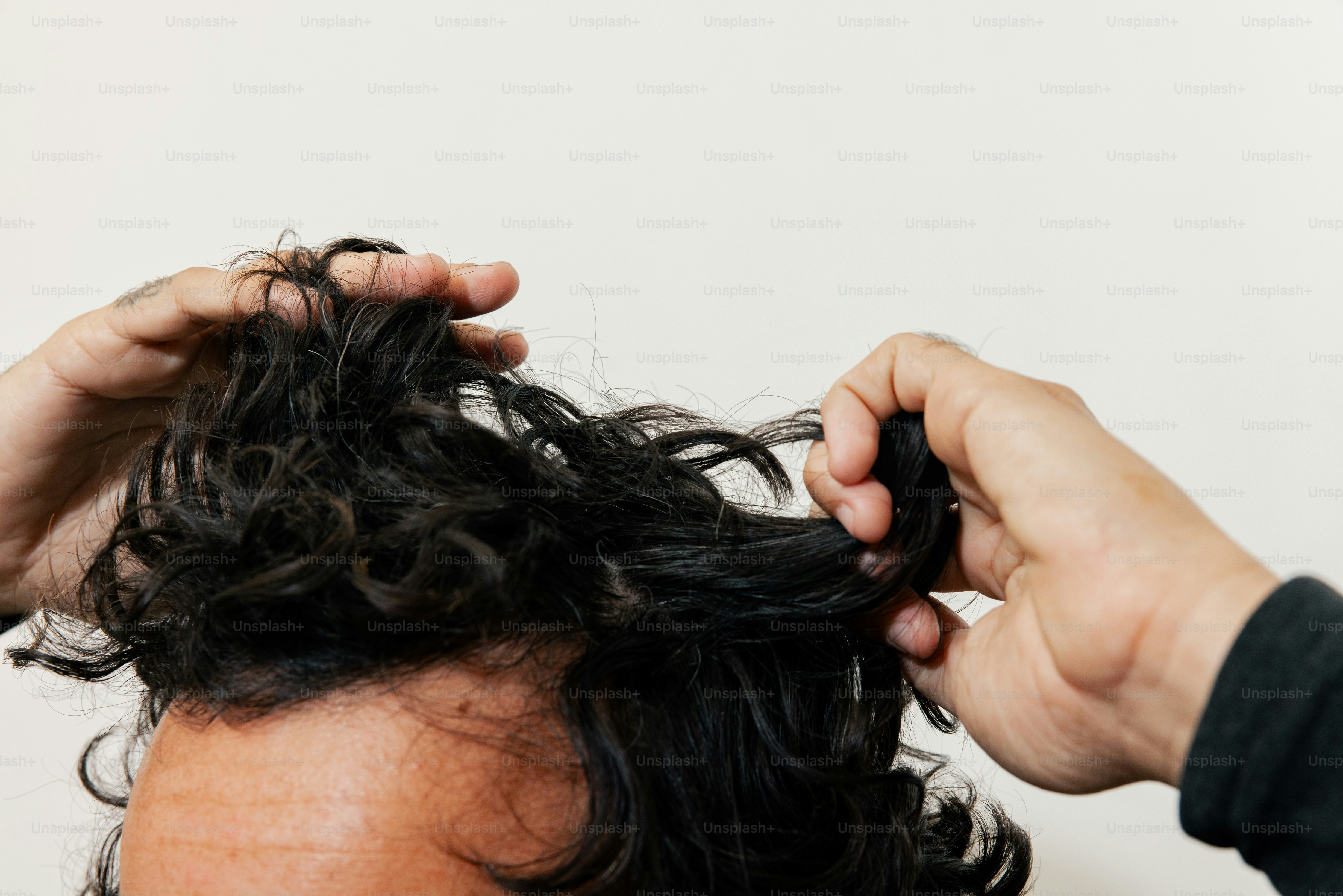 A man is cutting his hair with scissors
