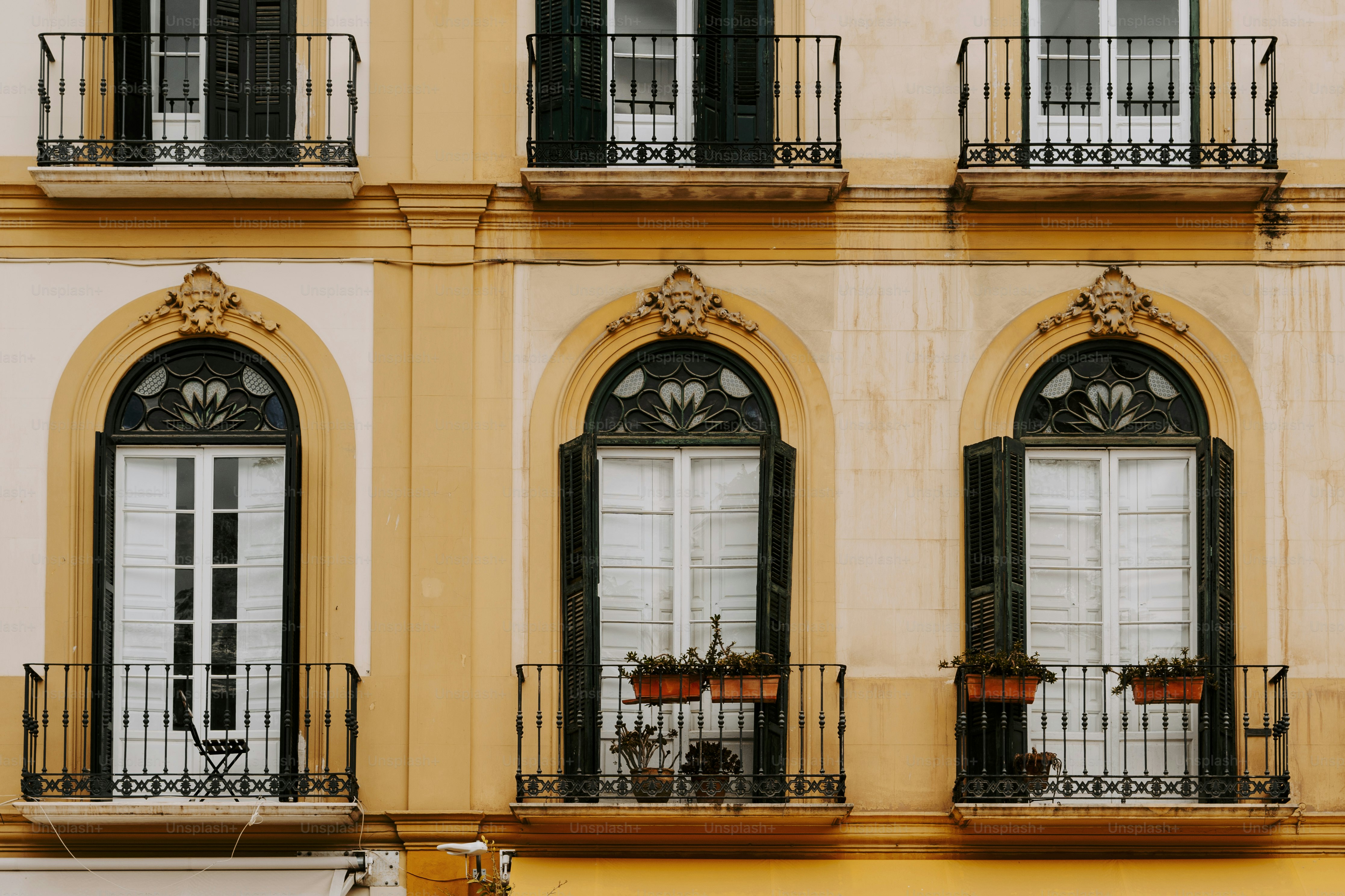 Un edificio amarillo con ventanas y balcones