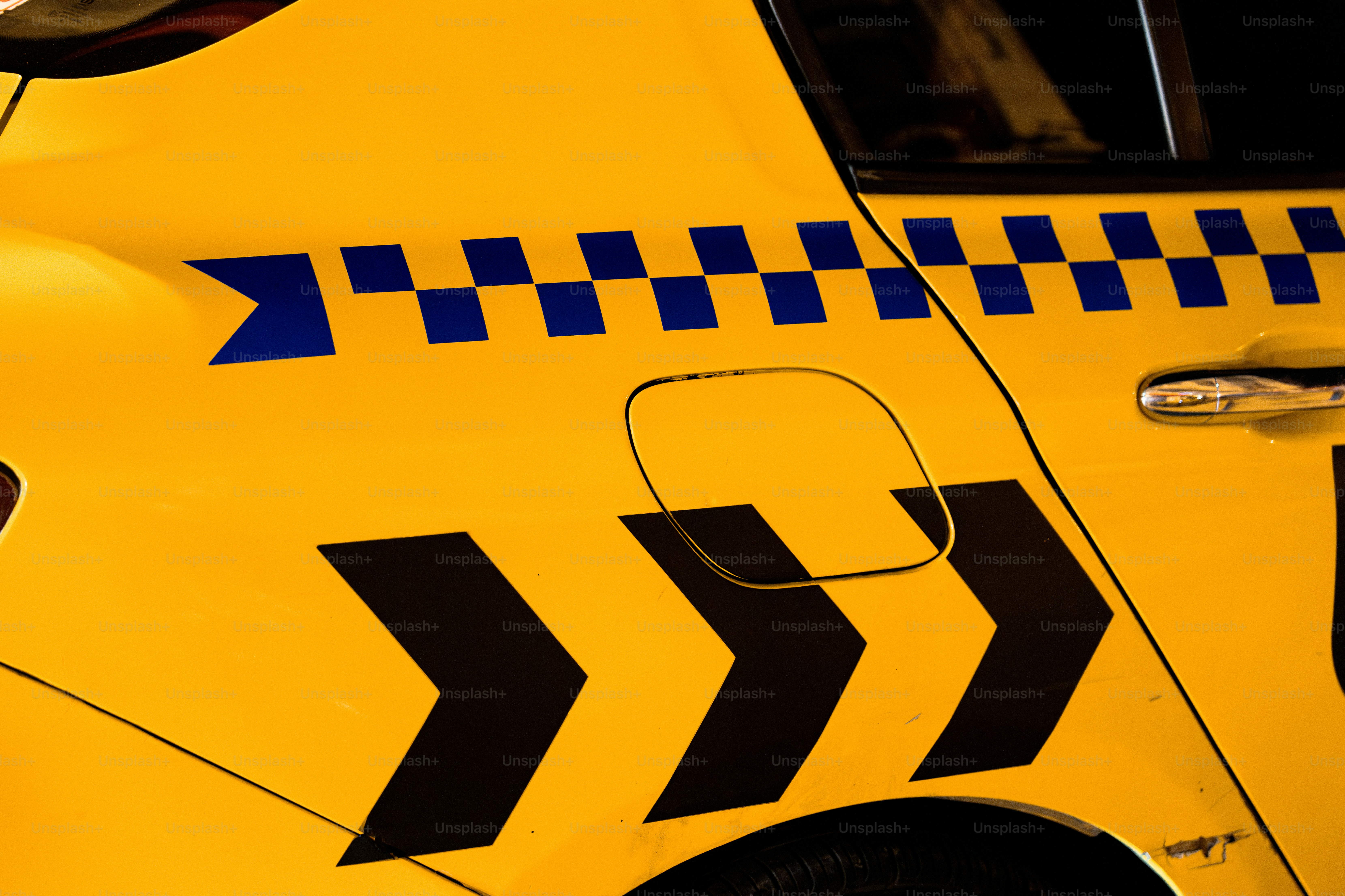 A close up of the side of a yellow taxi