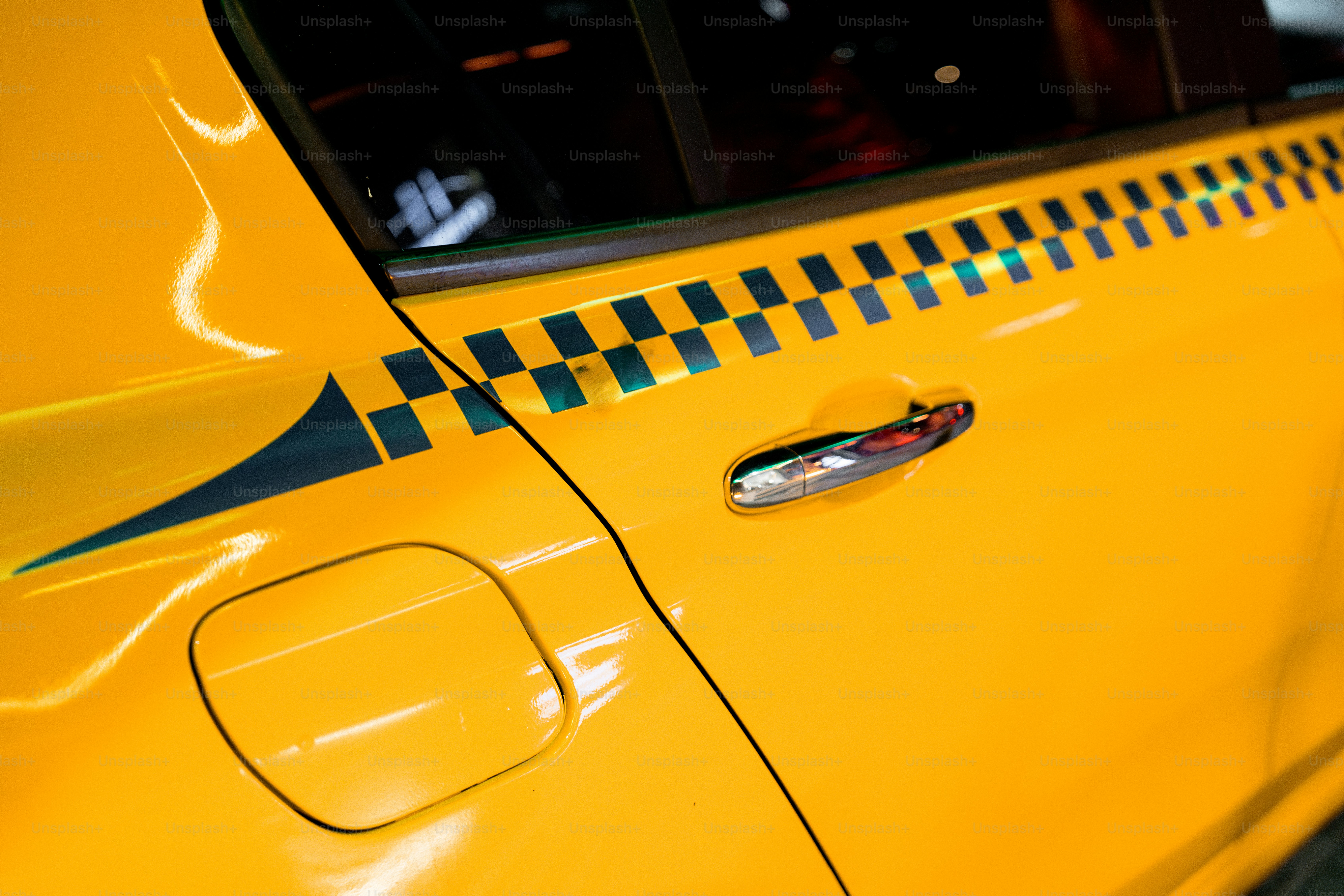 A close up of a yellow taxi with a checkered design