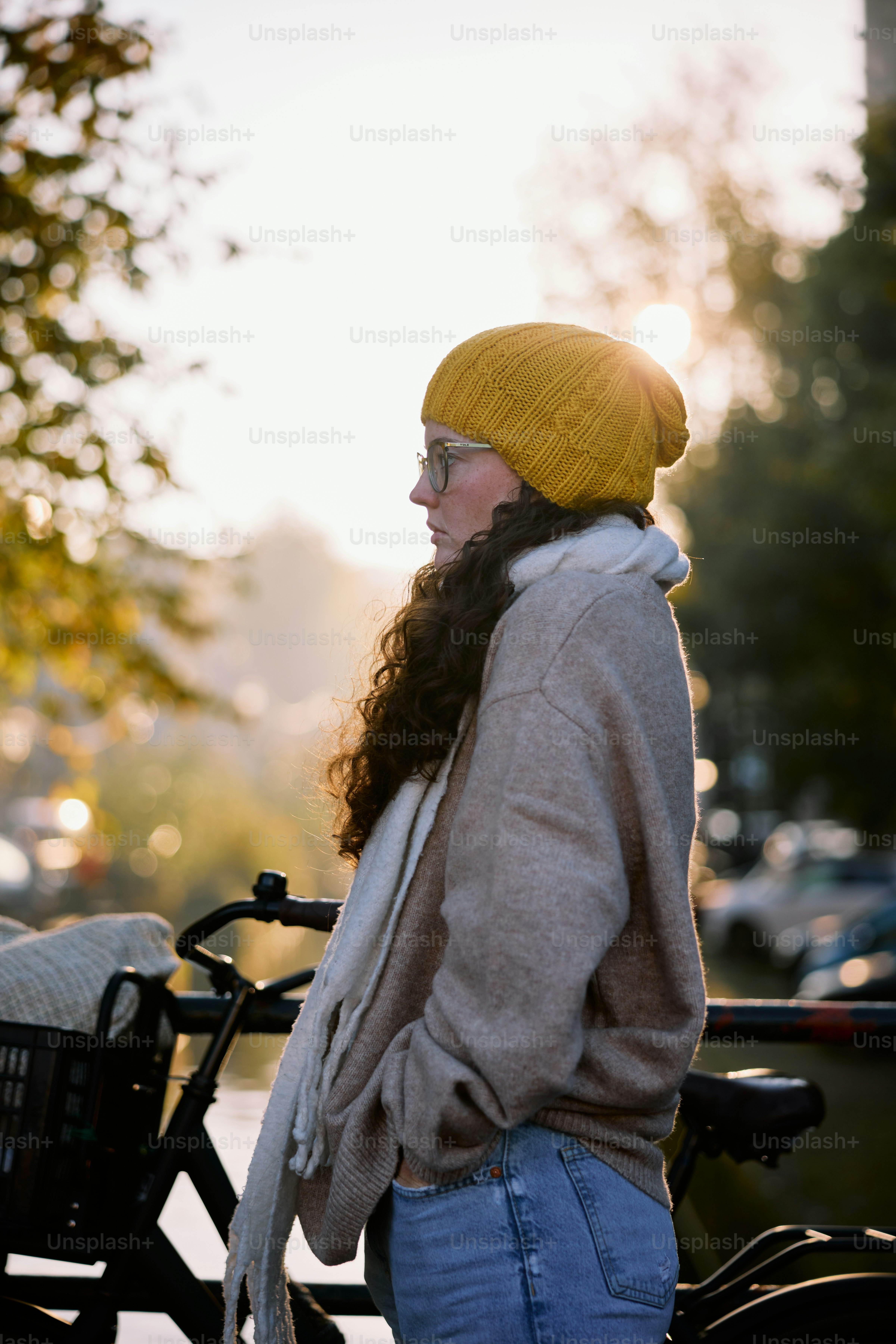 A woman standing next to a bicycle on a street