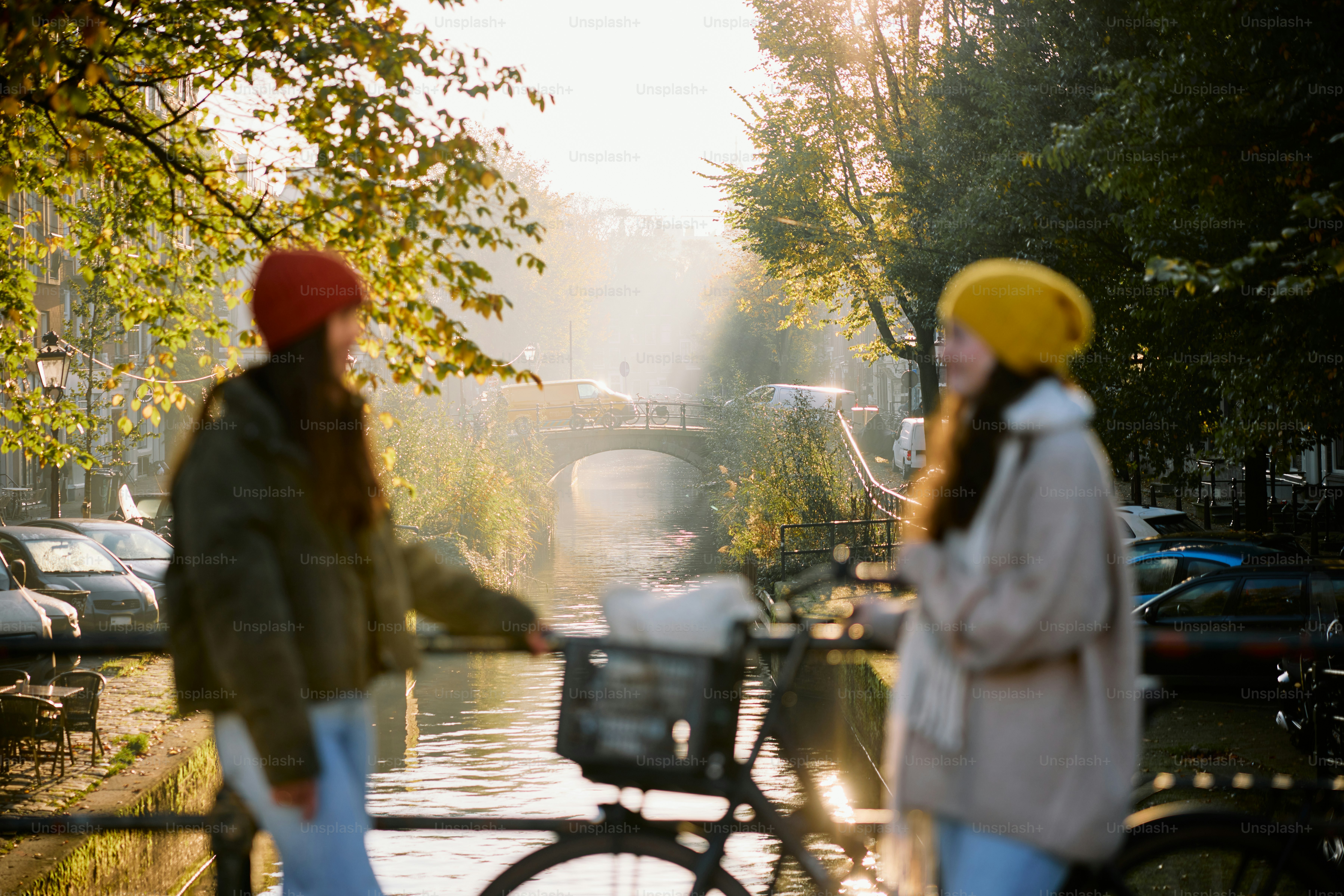 A couple of women walking down a street next to a bike