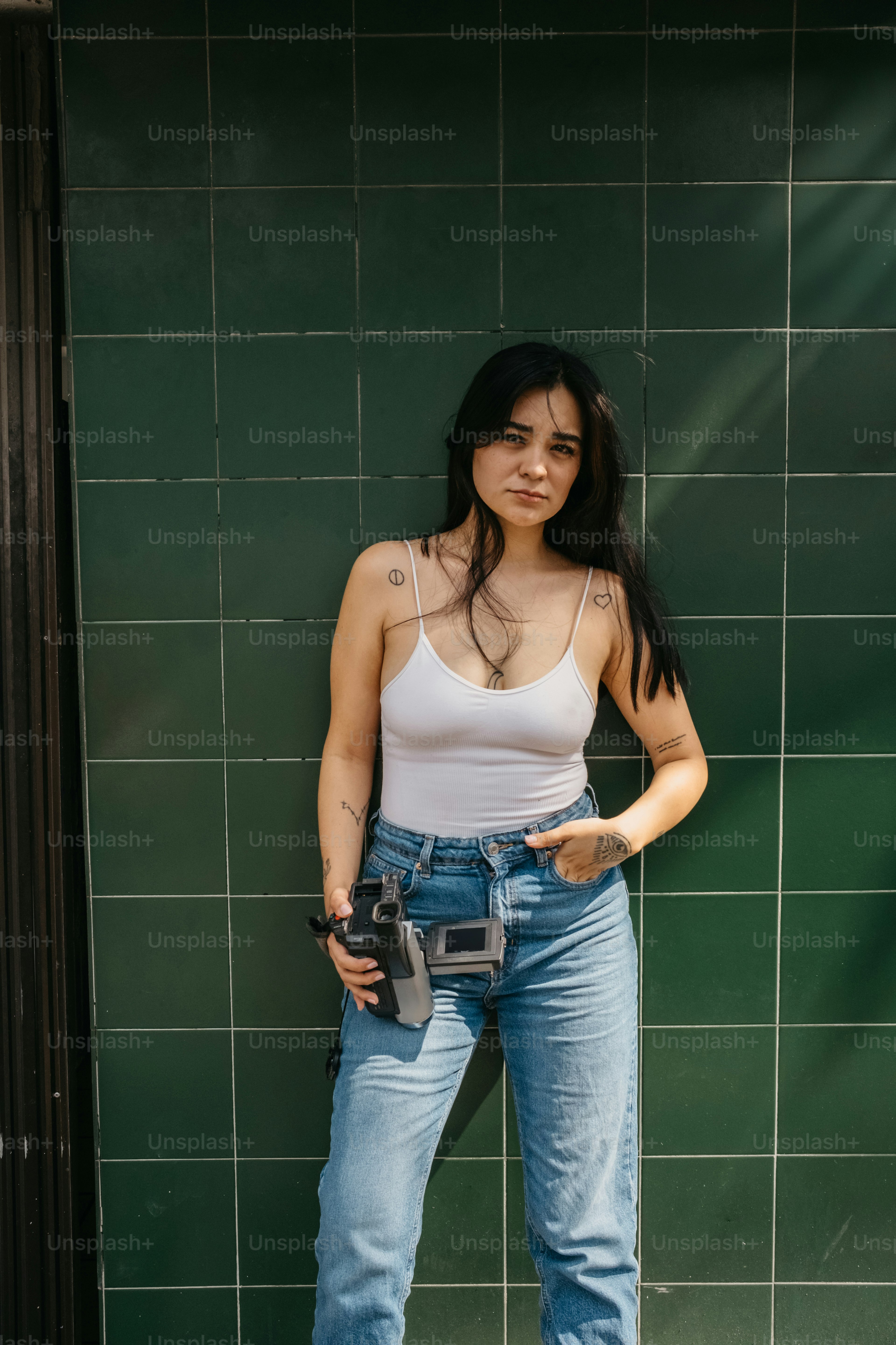 A woman standing in front of a green tiled wall