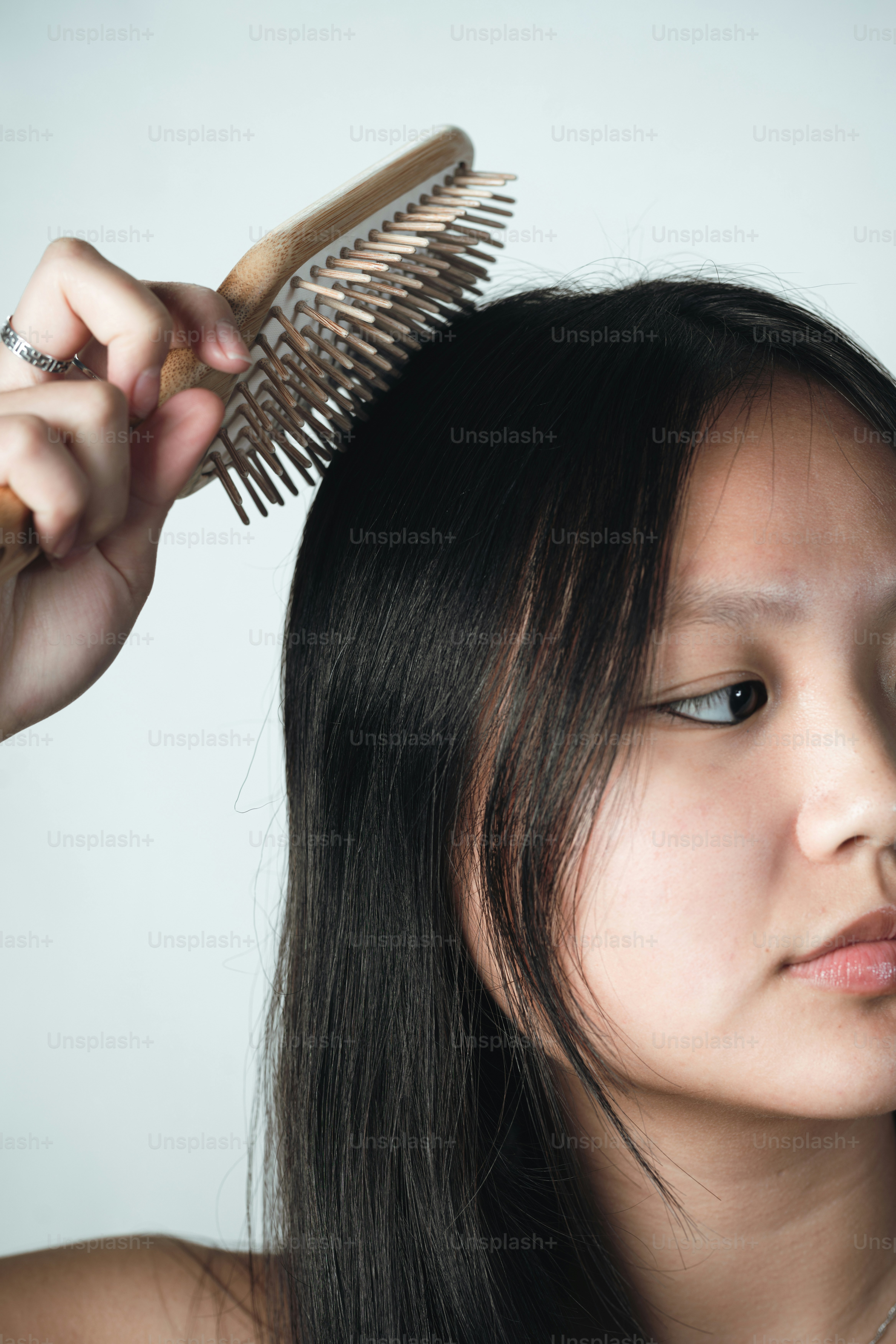 Eine Frau bürstet sich mit einer Bürste die Haare