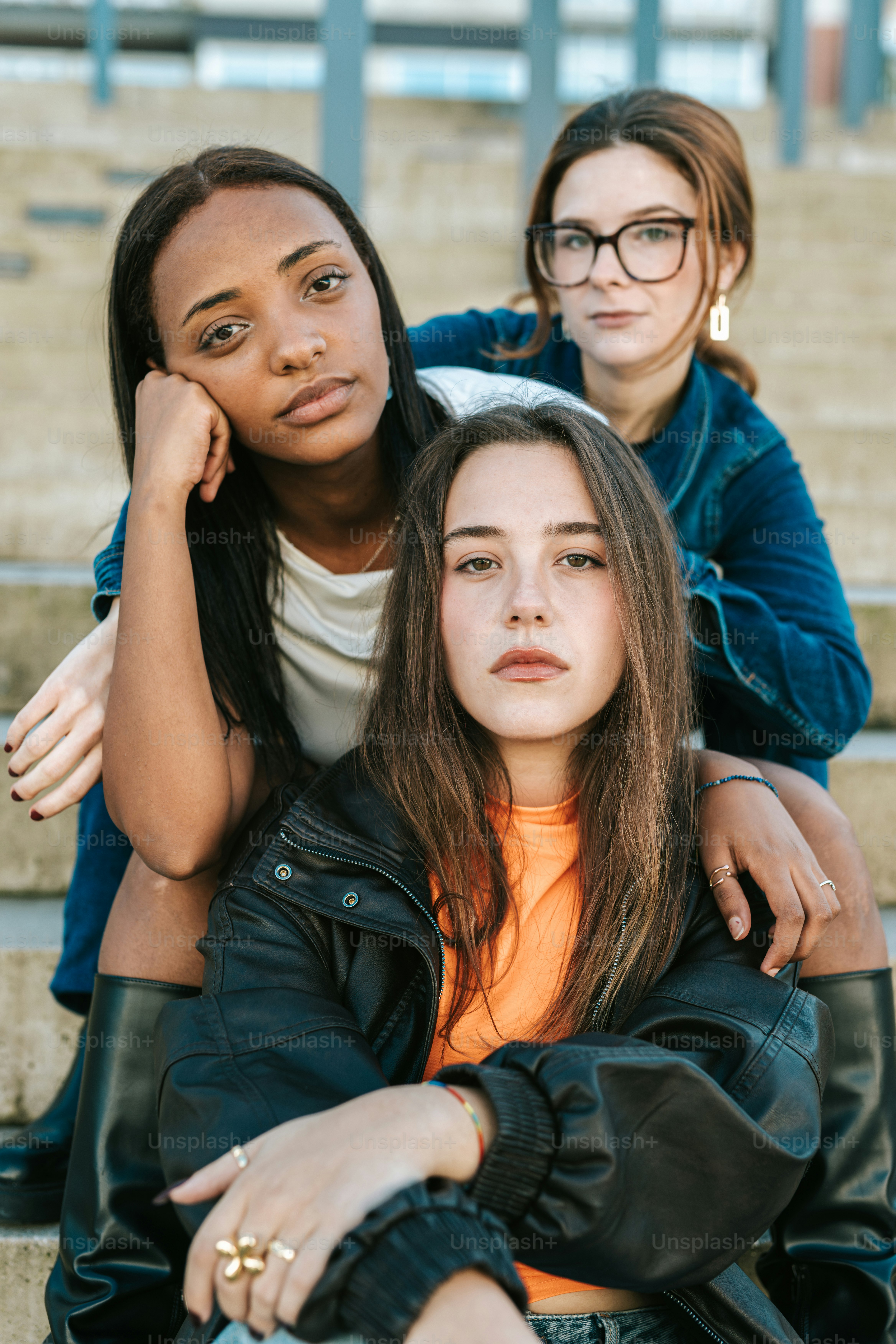 Three young women sitting on the steps of a building