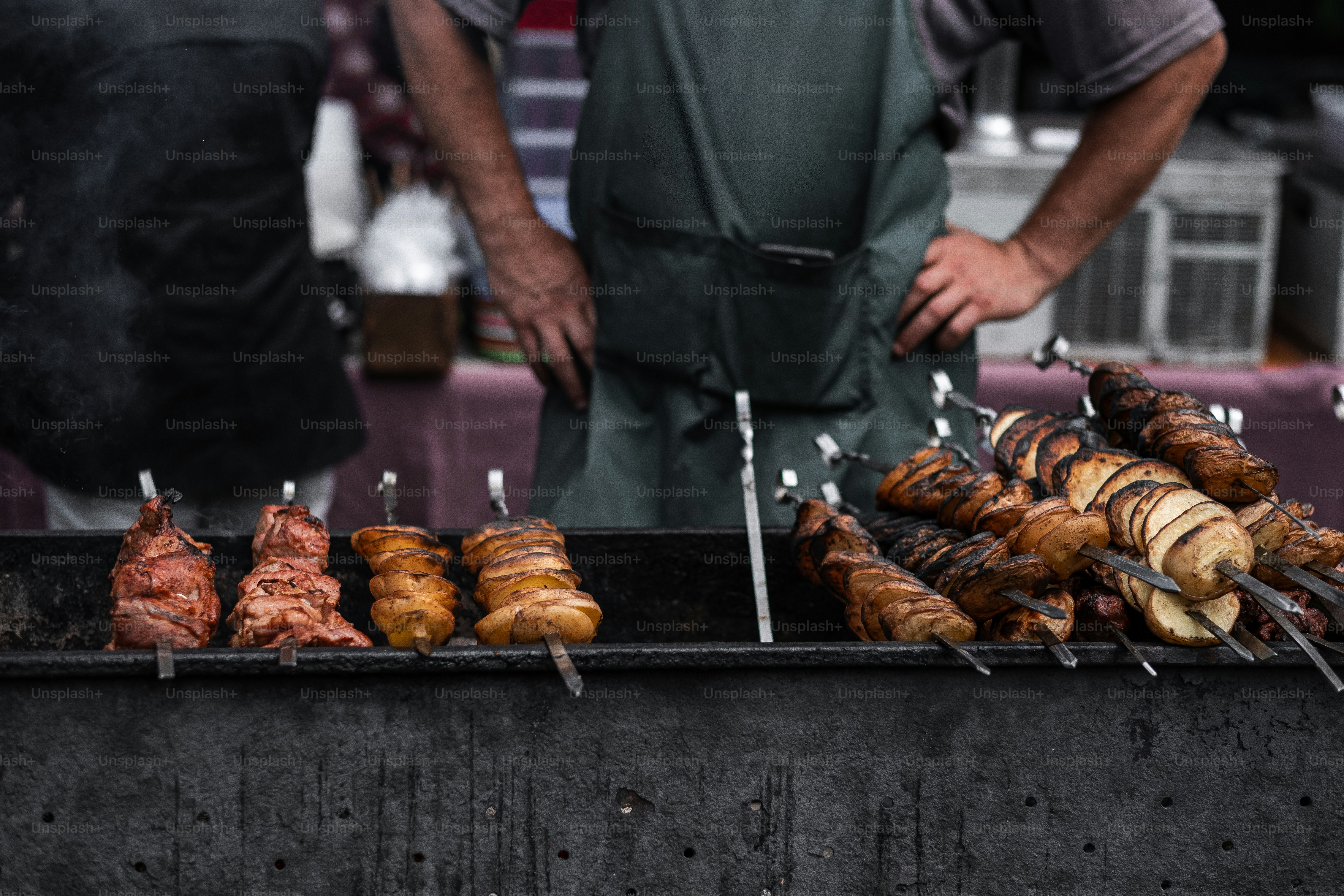 A man standing in front of a grill filled with food