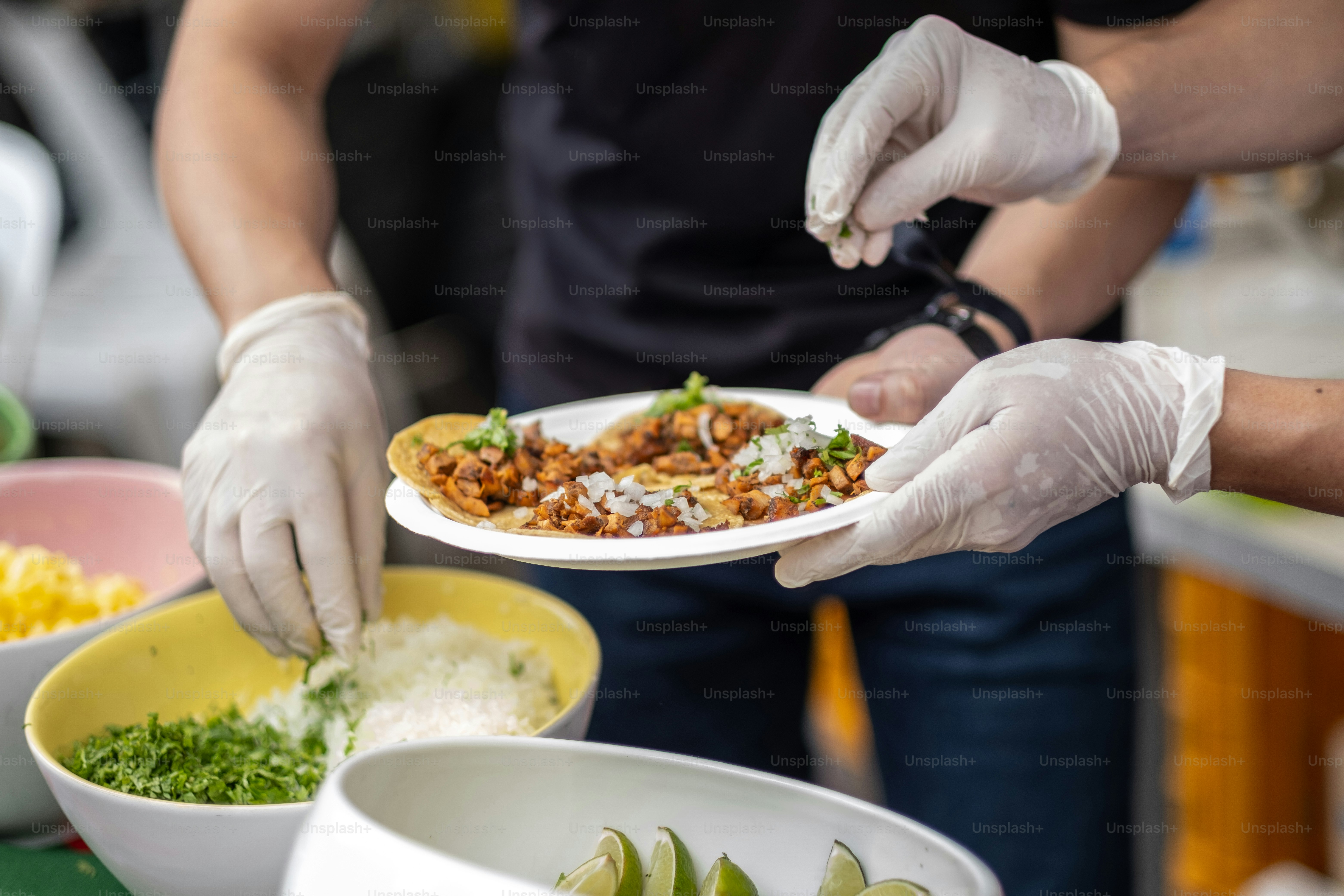 A person in white gloves is serving a plate of food