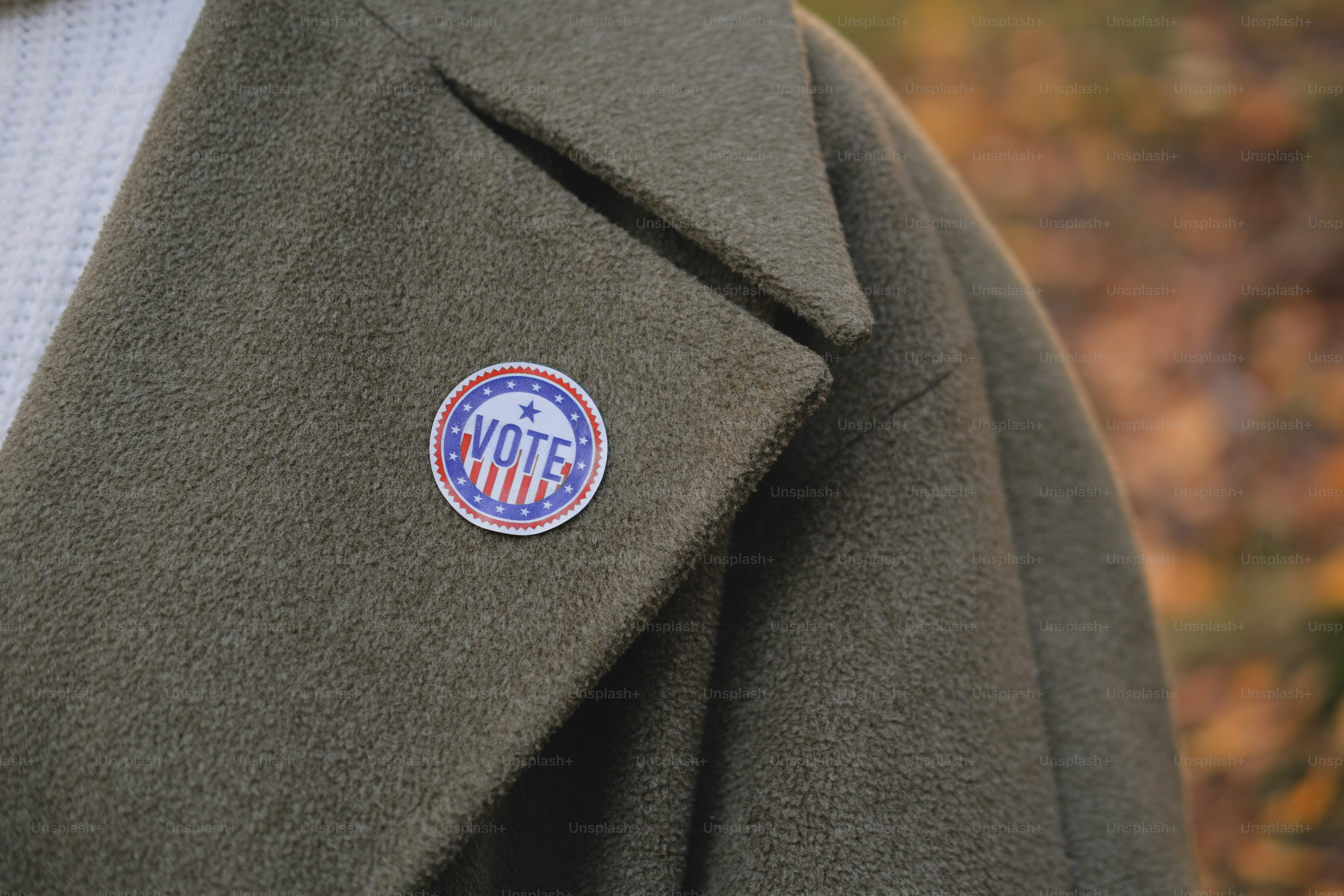 A close up of a person wearing a coat with a badge on it