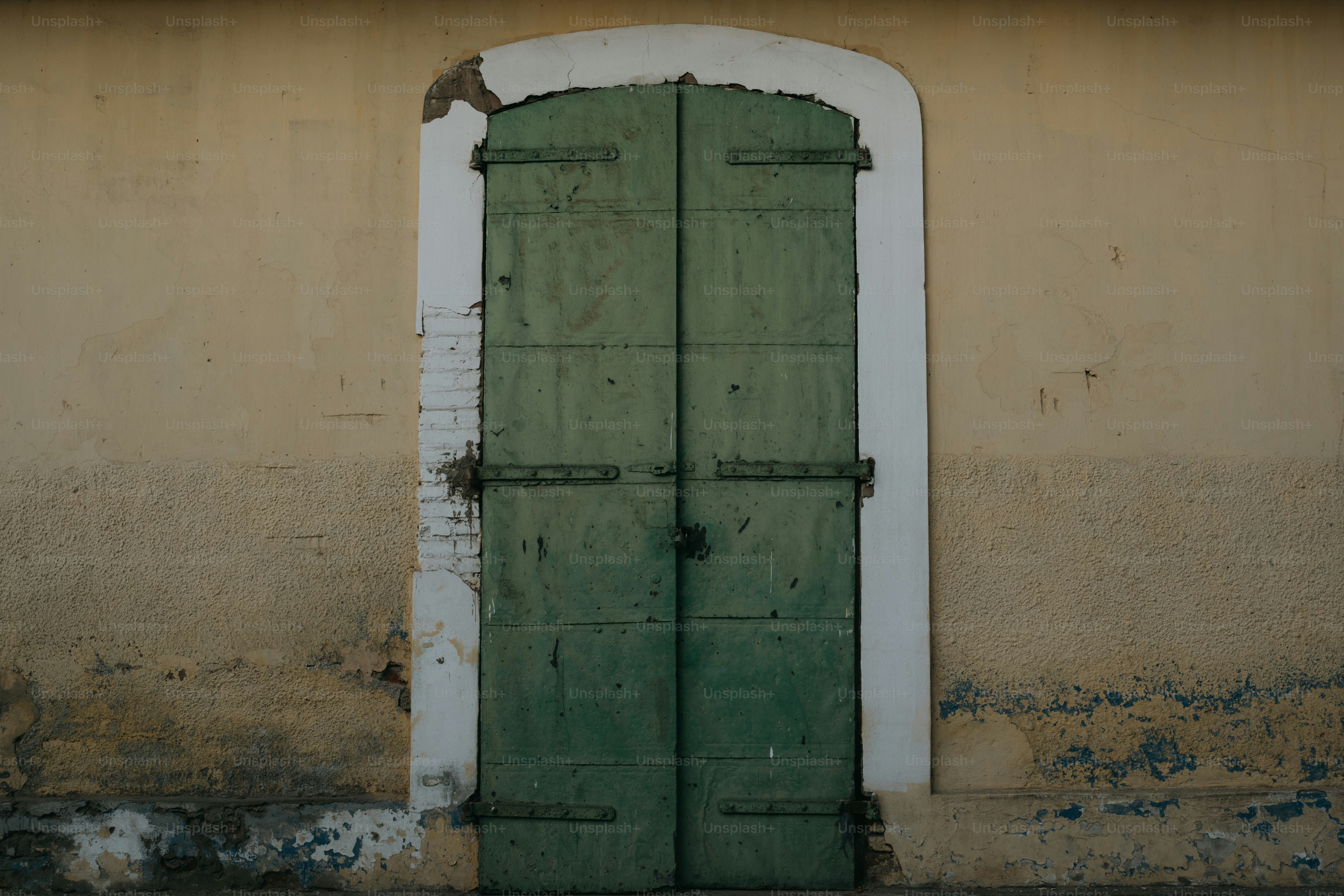 벽에 흰색 프레임이 있는 녹색 문