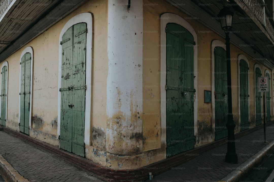 A building with green shutters and a clock on the top of it