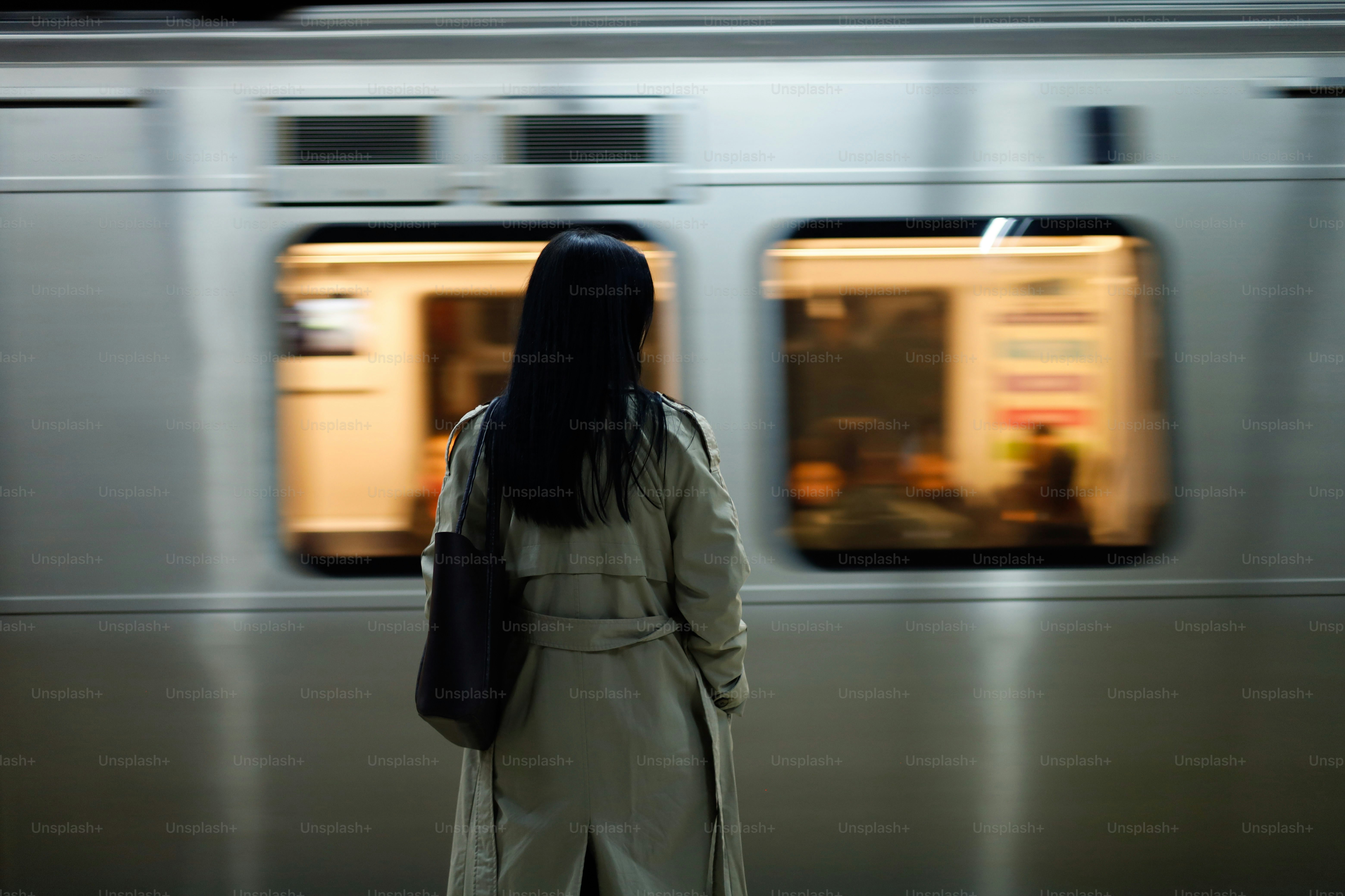 Una donna in piedi davanti a un treno della metropolitana
