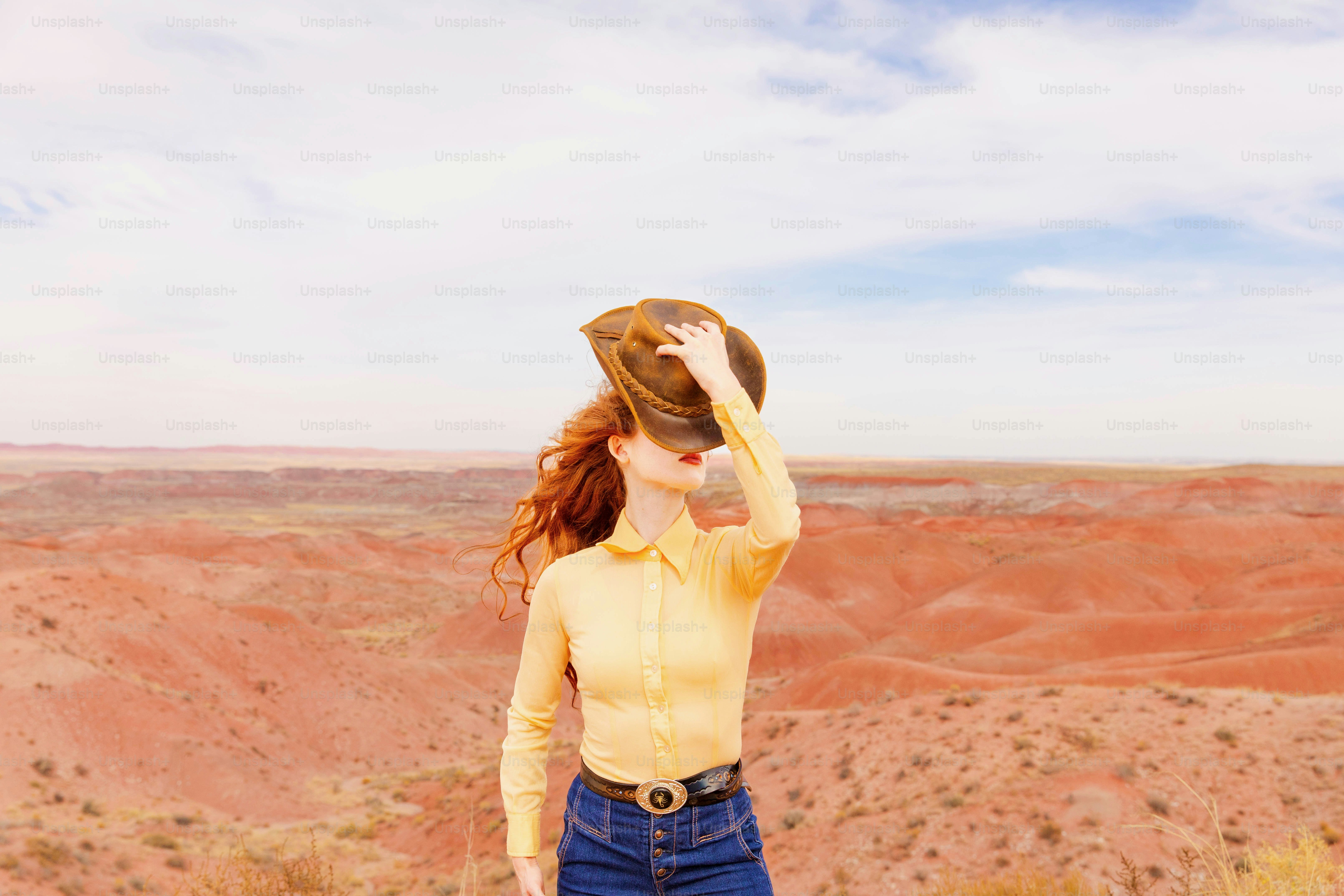 A woman in a yellow shirt is standing in the desert