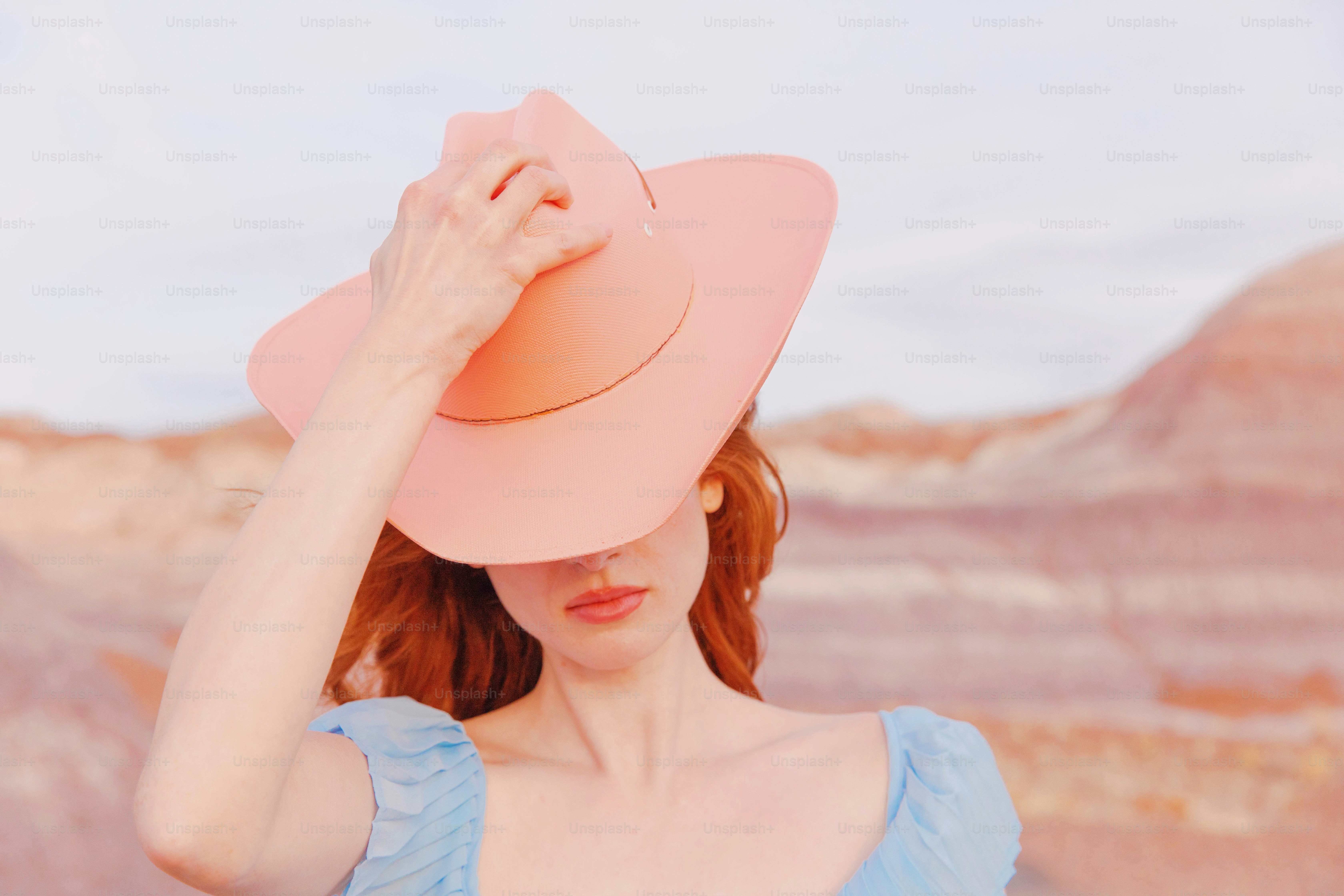 Una donna con un vestito blu e un cappello rosa