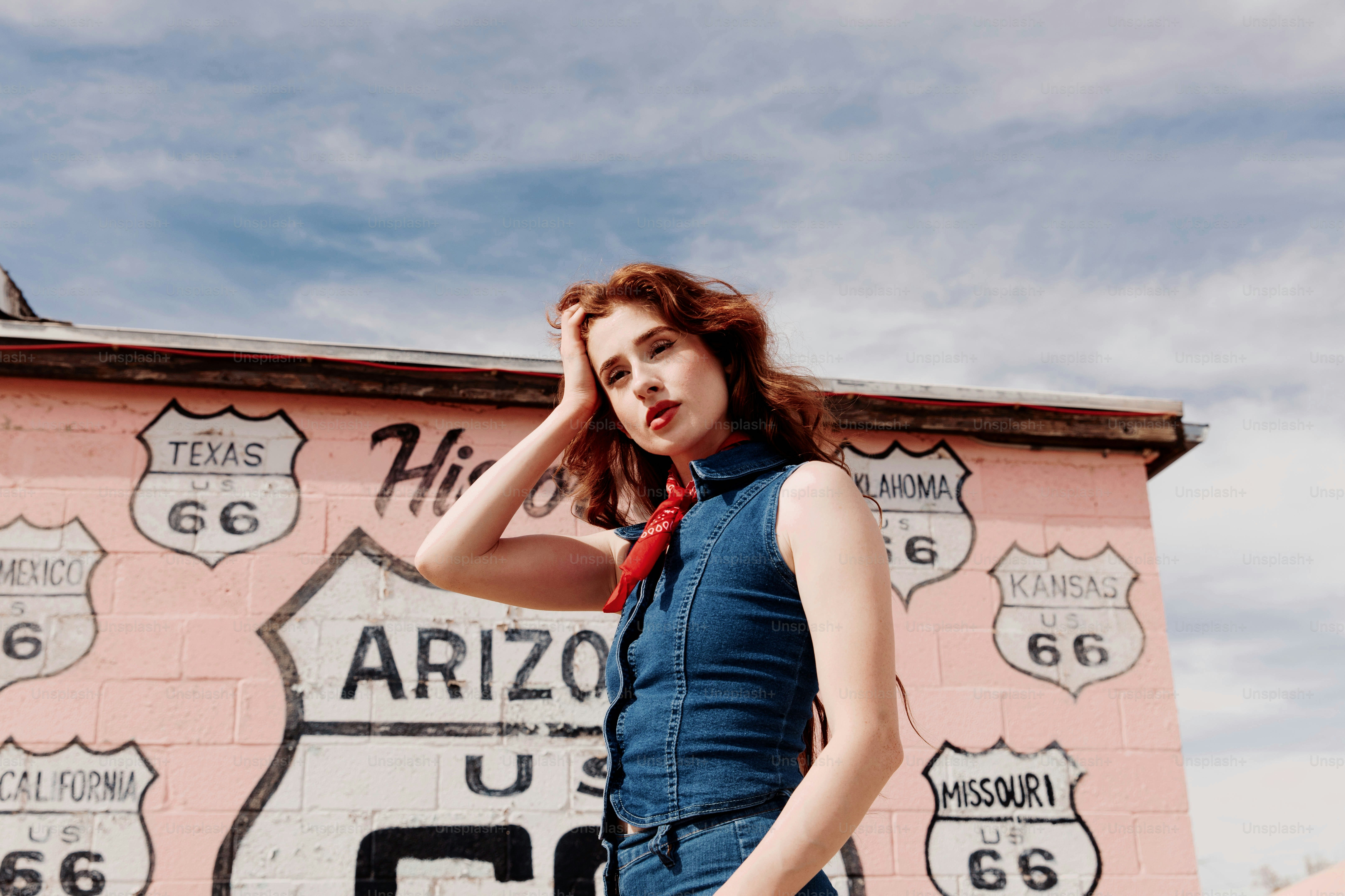 Une femme debout devant un bâtiment rose