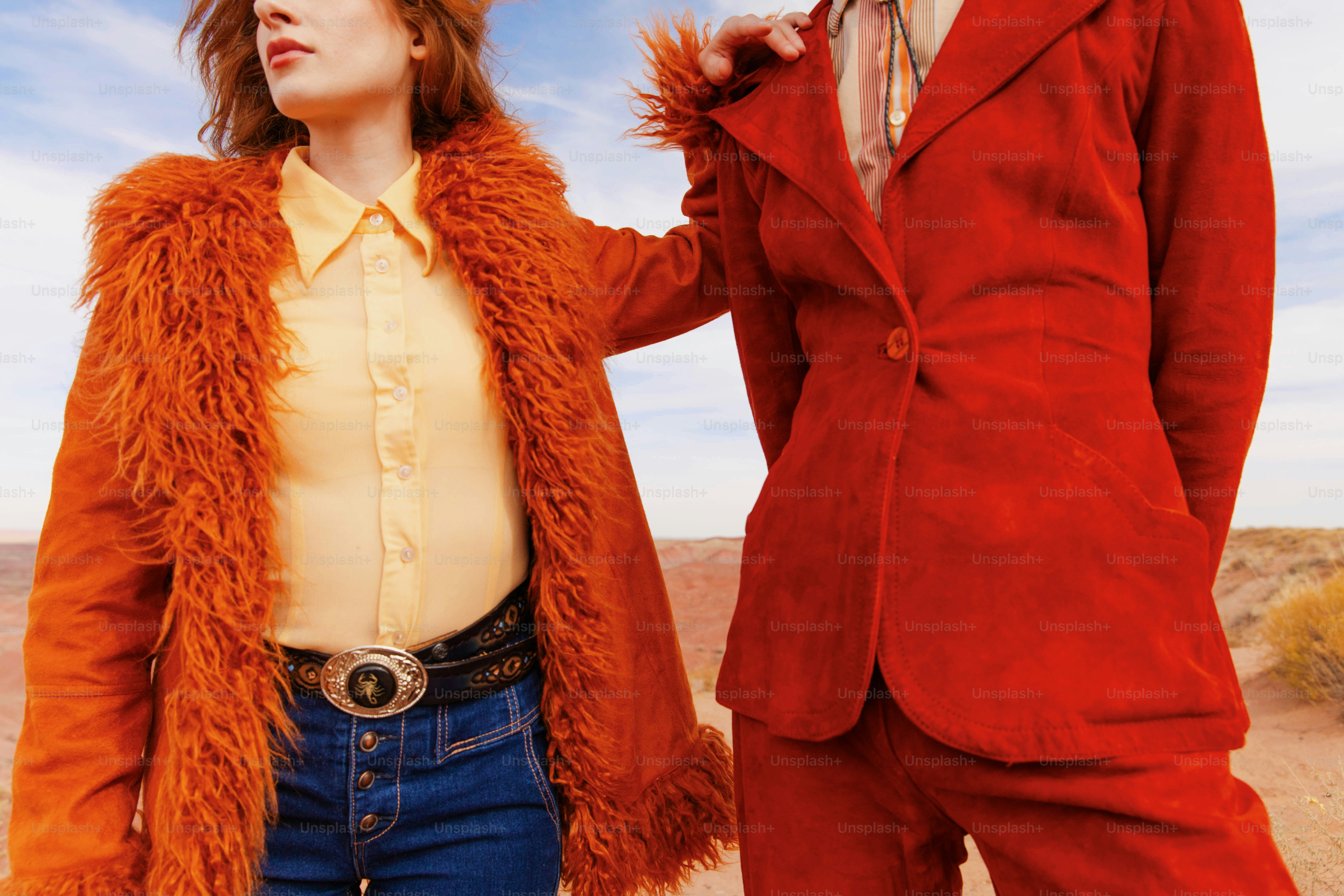 un uomo e una donna vestiti di rosso in piedi nel deserto