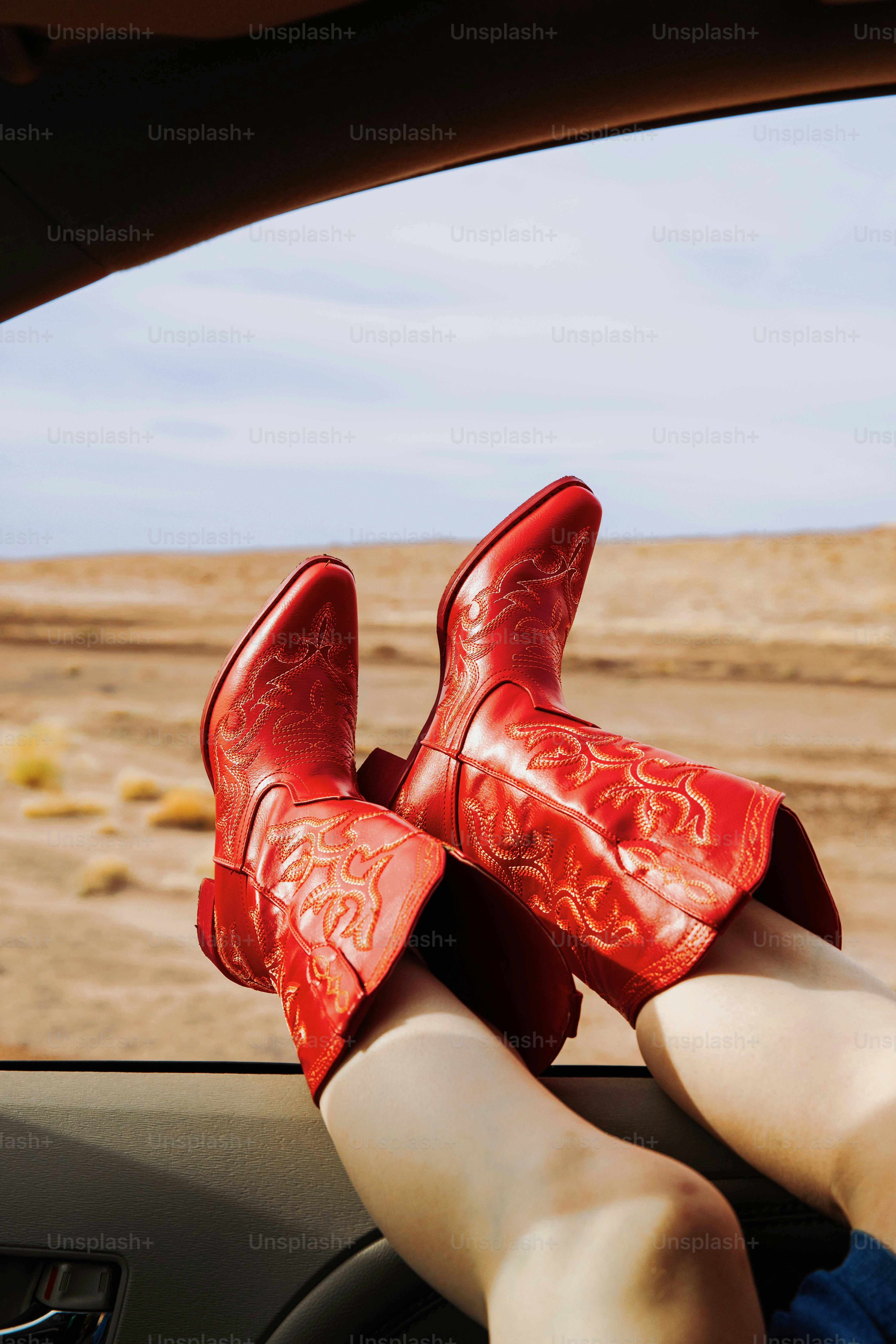 A woman wearing red high heels sitting in a car