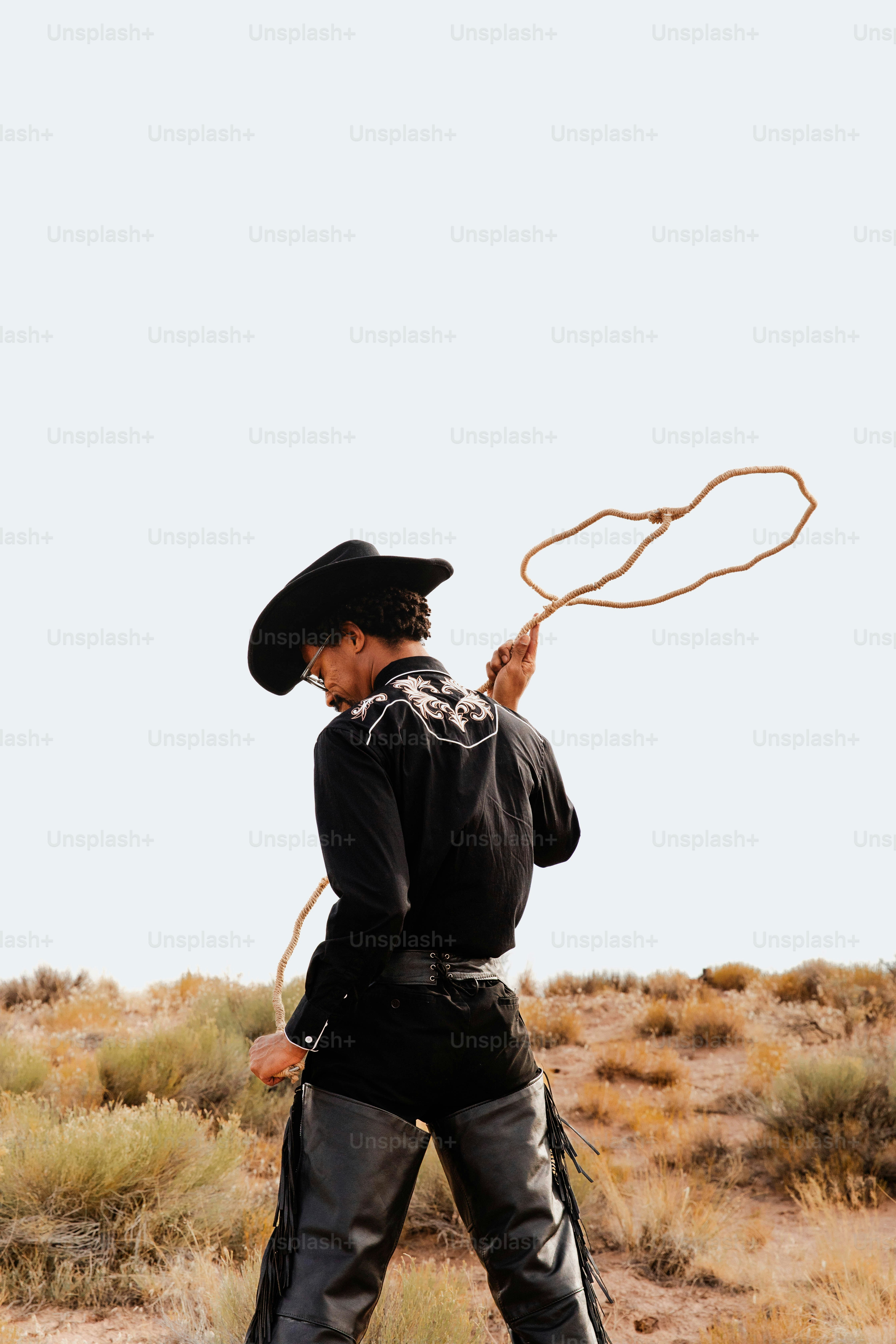 A man in a black outfit is playing with a rope
