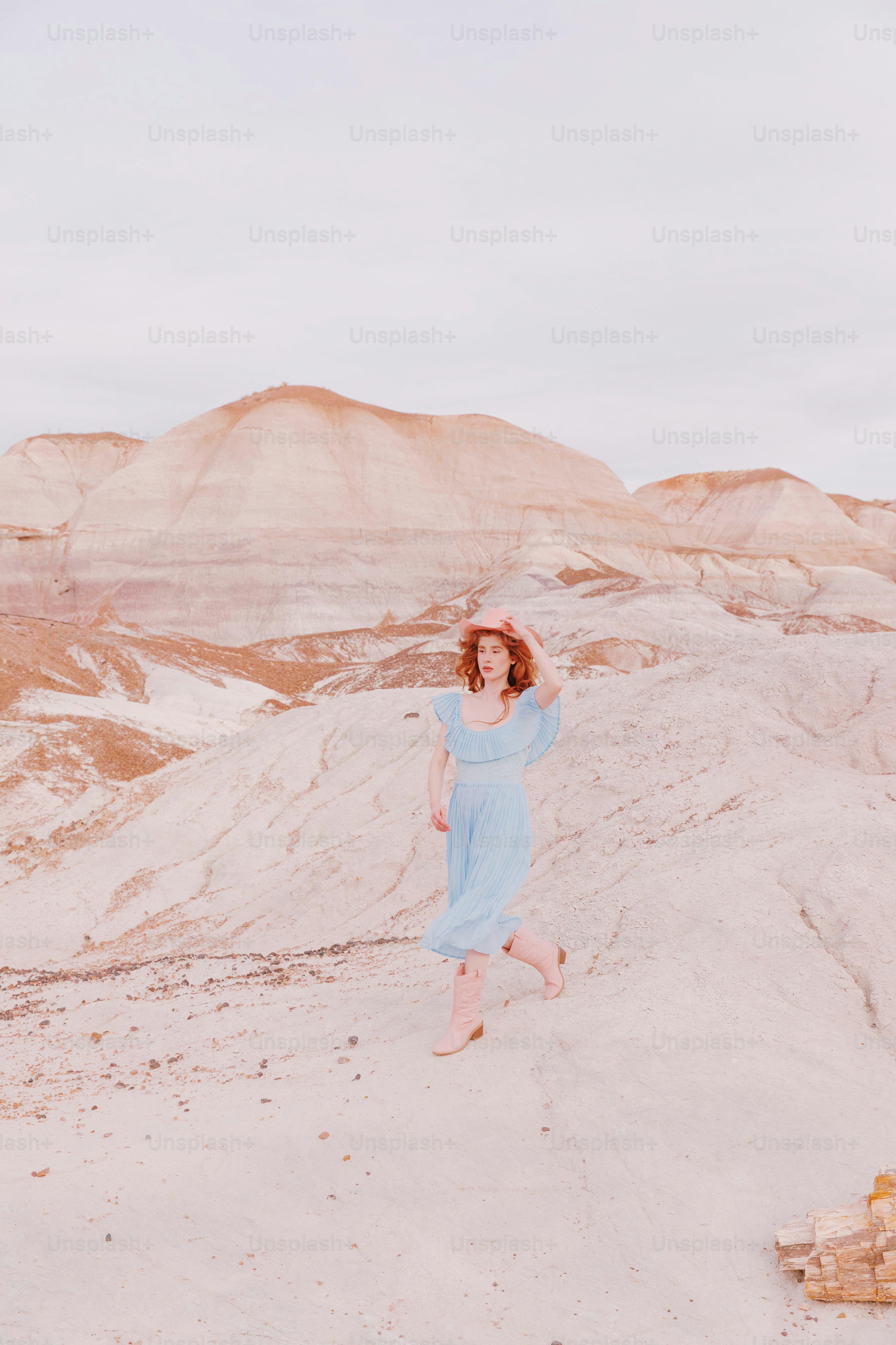 A woman in a blue dress standing in the desert photo – Desert landscape ...