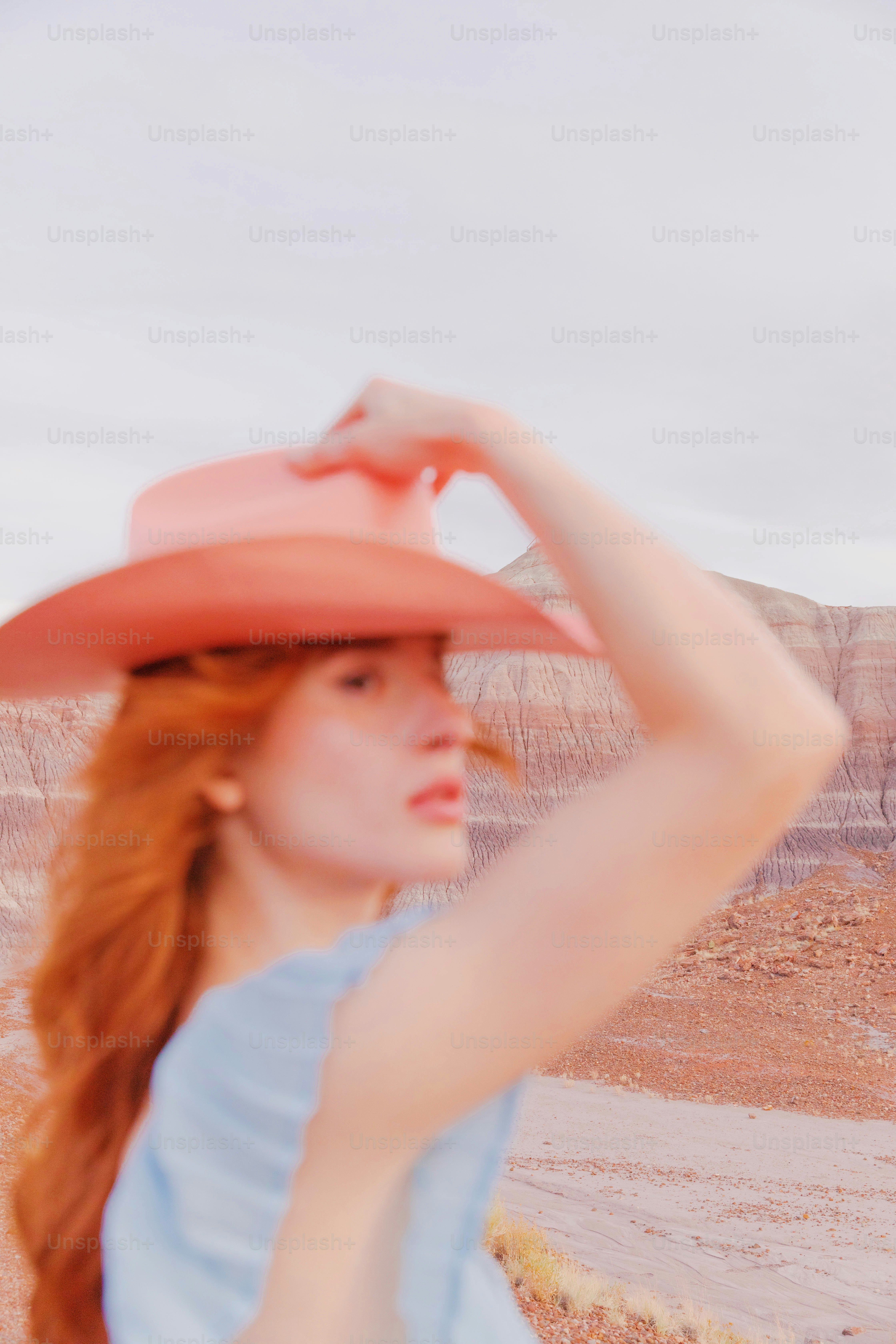 Una mujer con un sombrero rosa en el desierto
