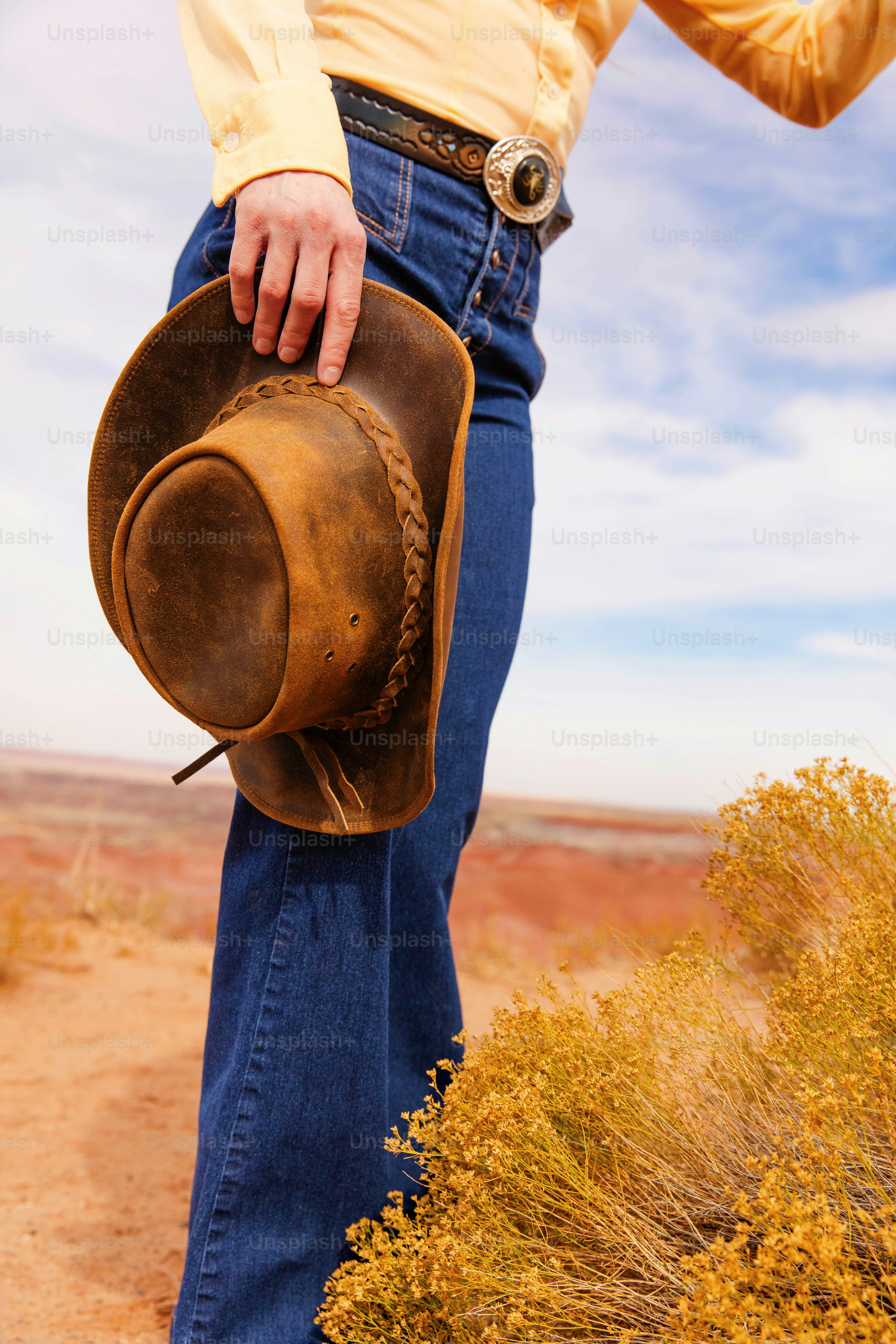 Un homme portant un chapeau de cow-boy debout dans le désert