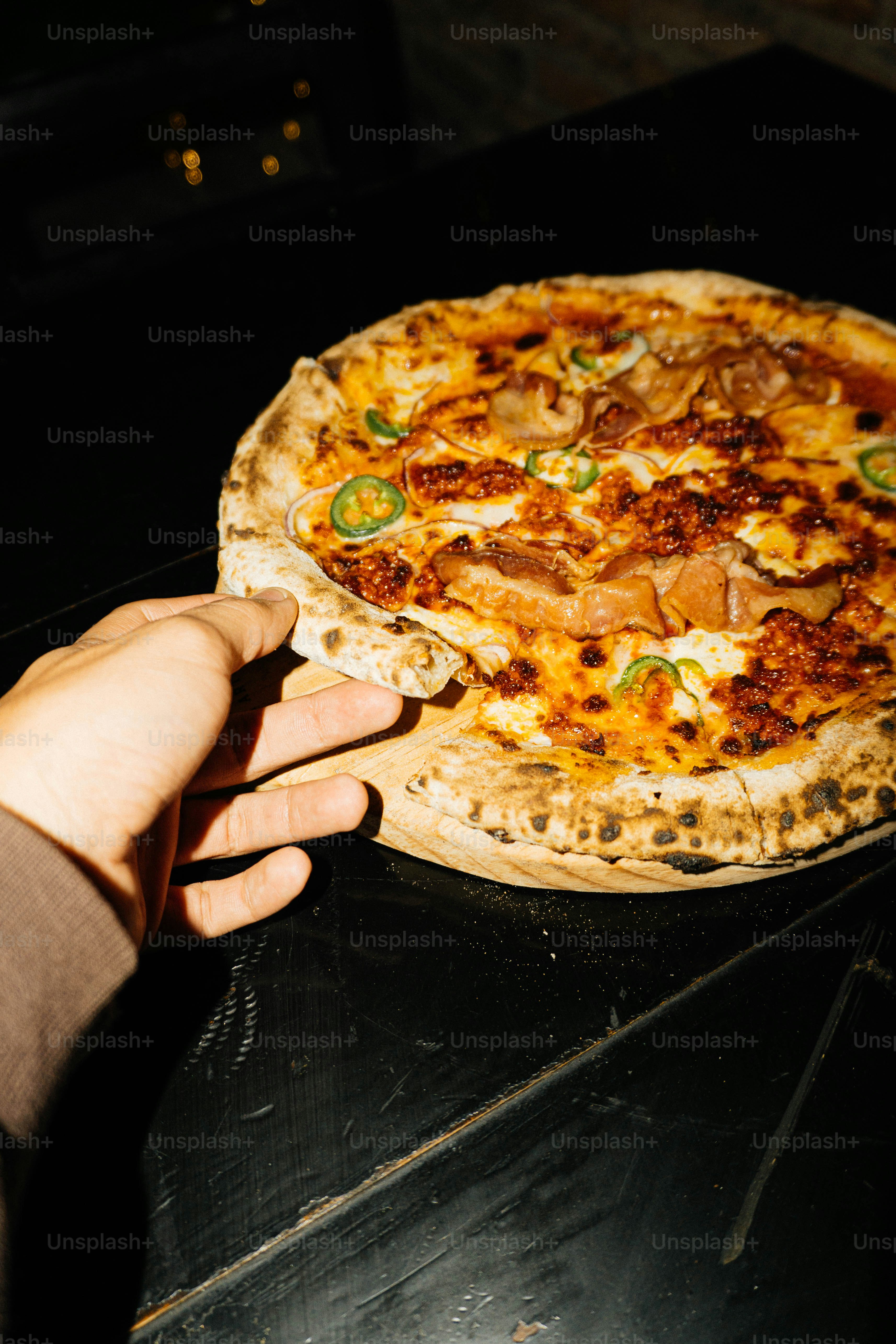 A person holding a pizza in their hand