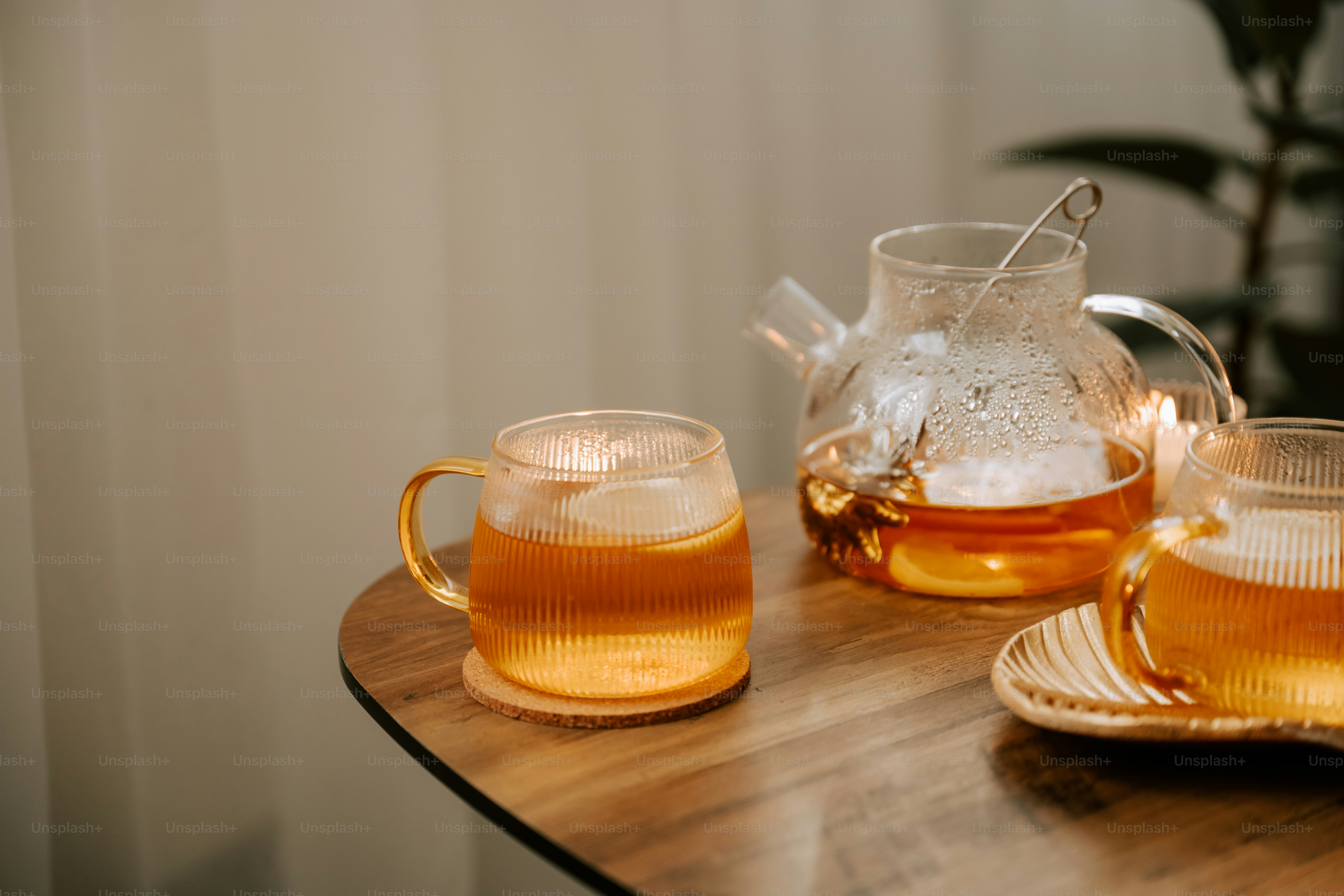 A wooden table topped with two cups of tea